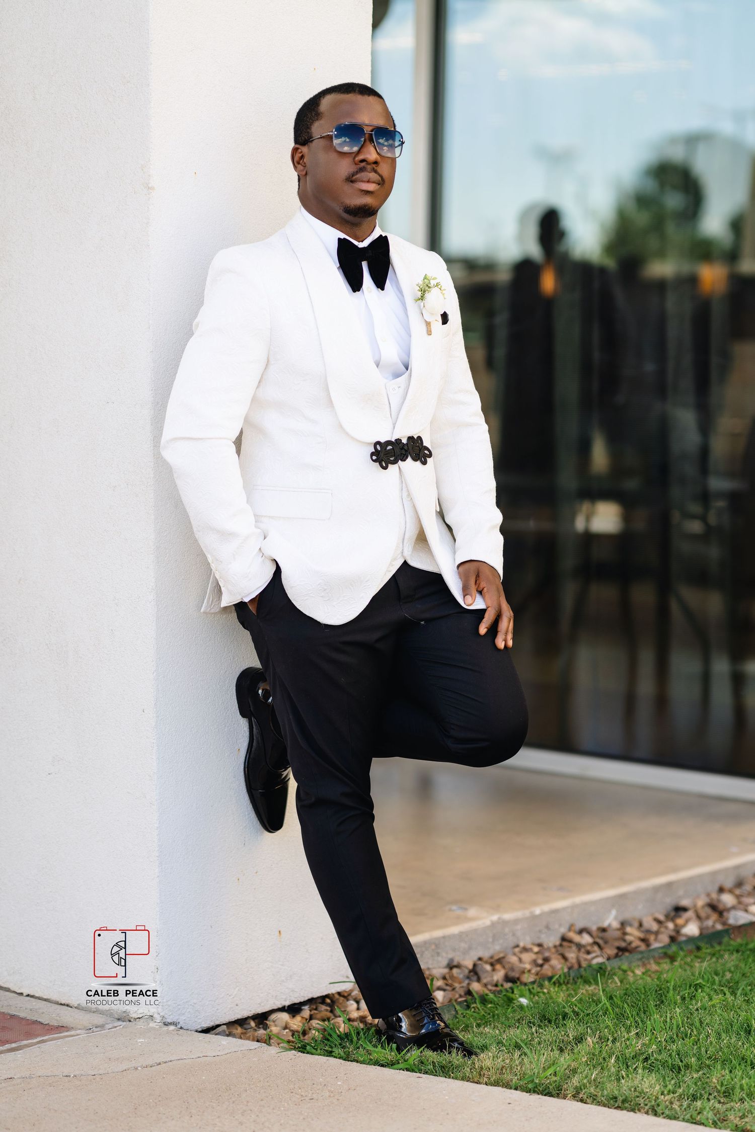 A person in a white tuxedo jacket and black pants poses elegantly in three different outdoor settings.