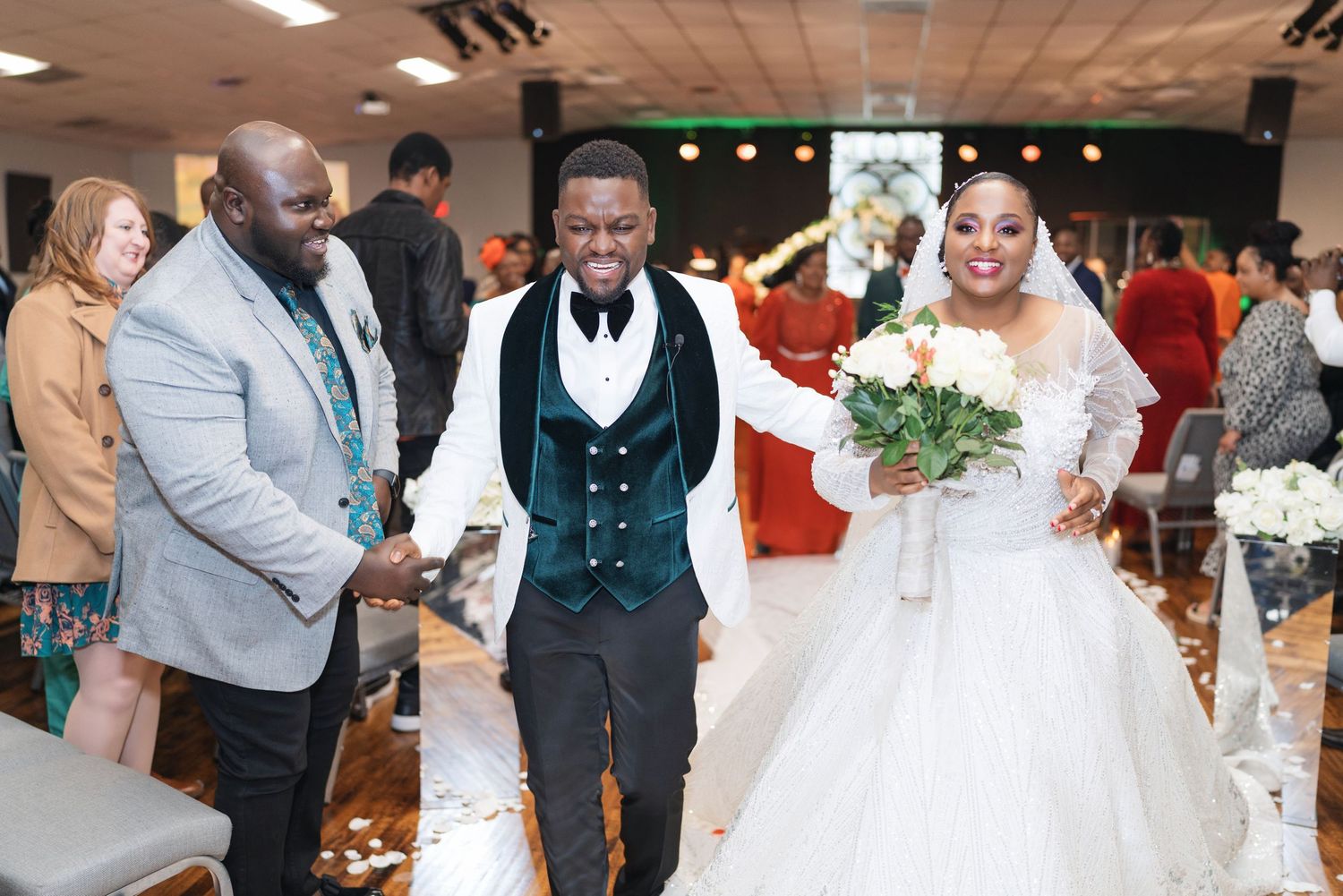A wedding reception scene showing guests mingling and celebrating in an elegant ballroom setting.