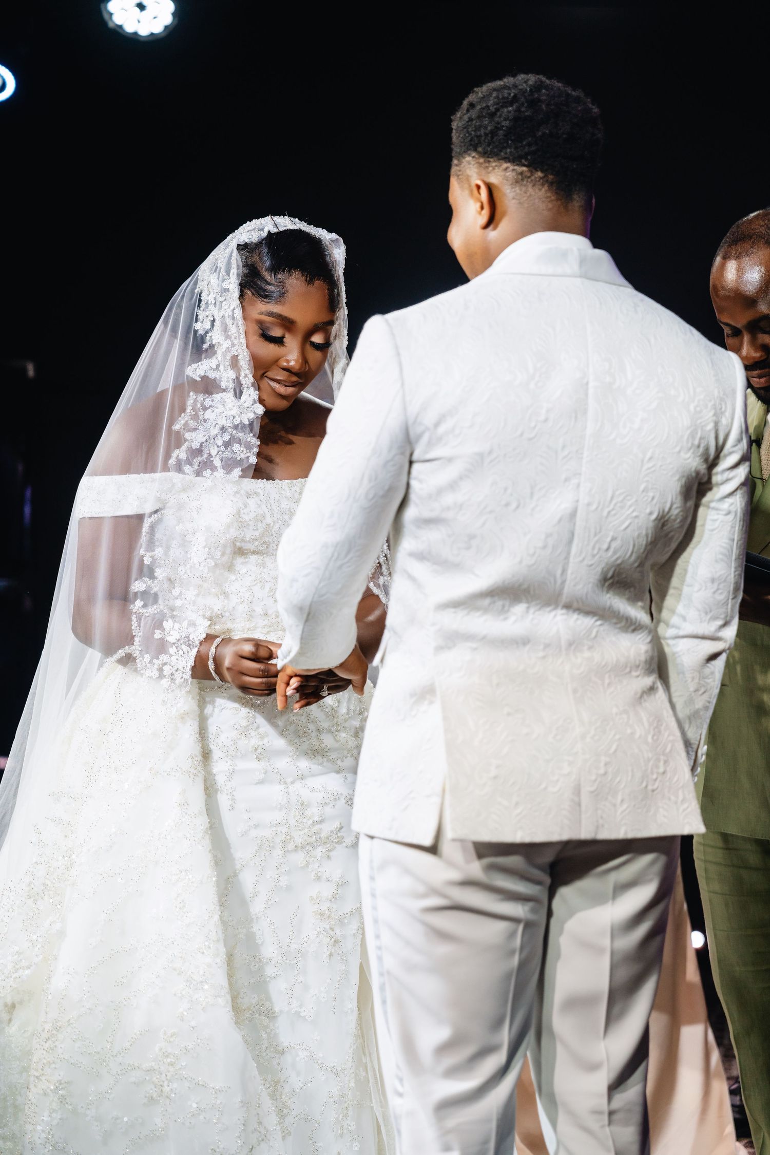 Elegant wedding ceremony featuring couple in white attire exchanging rings during intimate moment.