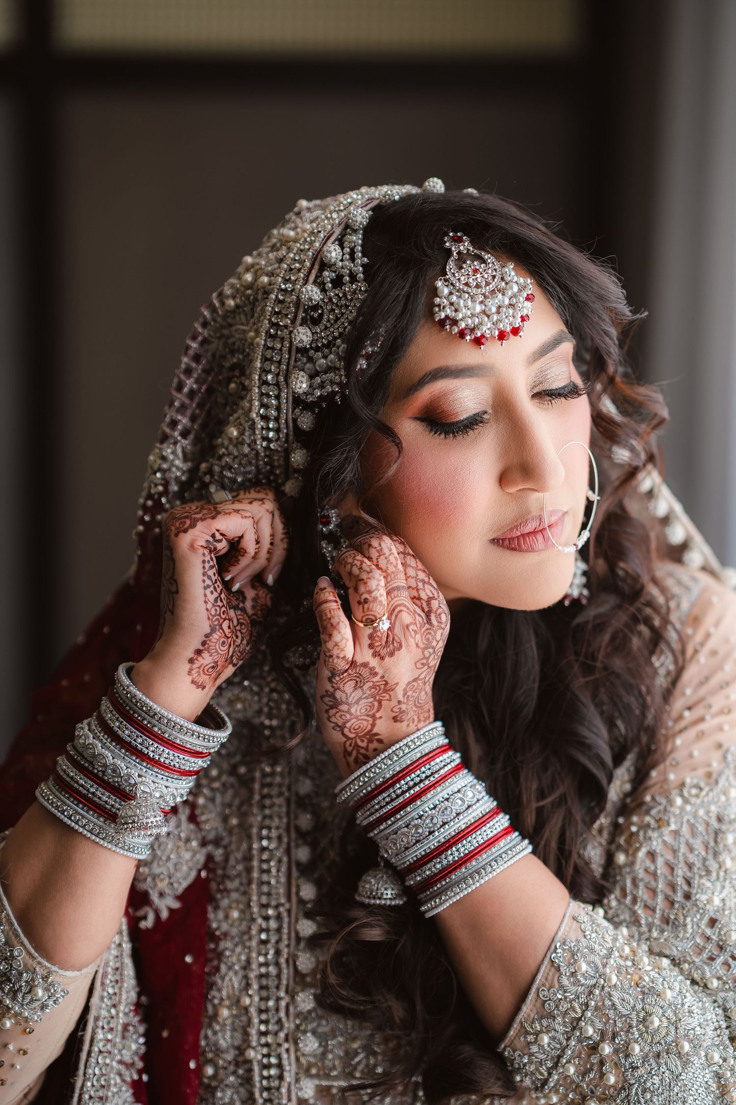 Close-up shots of traditional South Asian bridal jewelry and makeup details in silver and white.