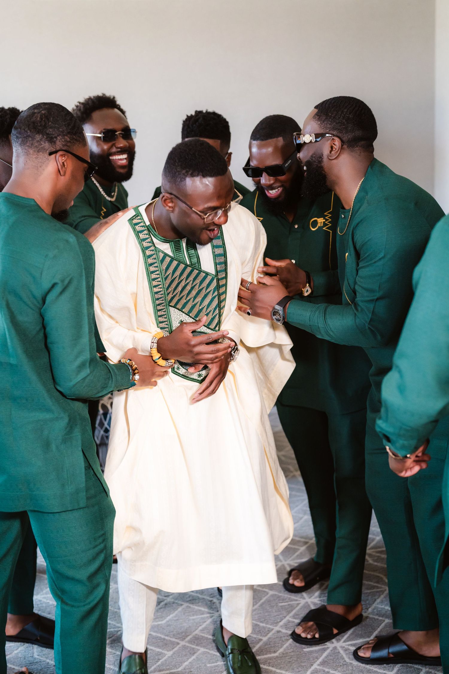 A group wearing green uniforms and white outfits gather together in a casual setting.