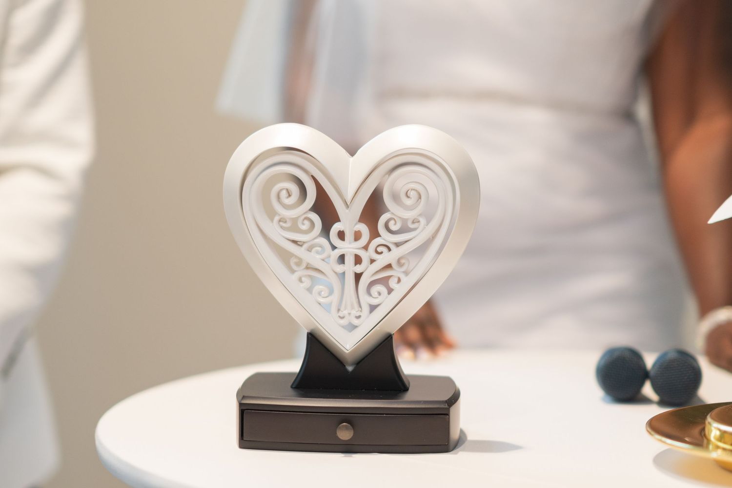 White decorative heart-shaped wedding cake toppers displayed at reception.