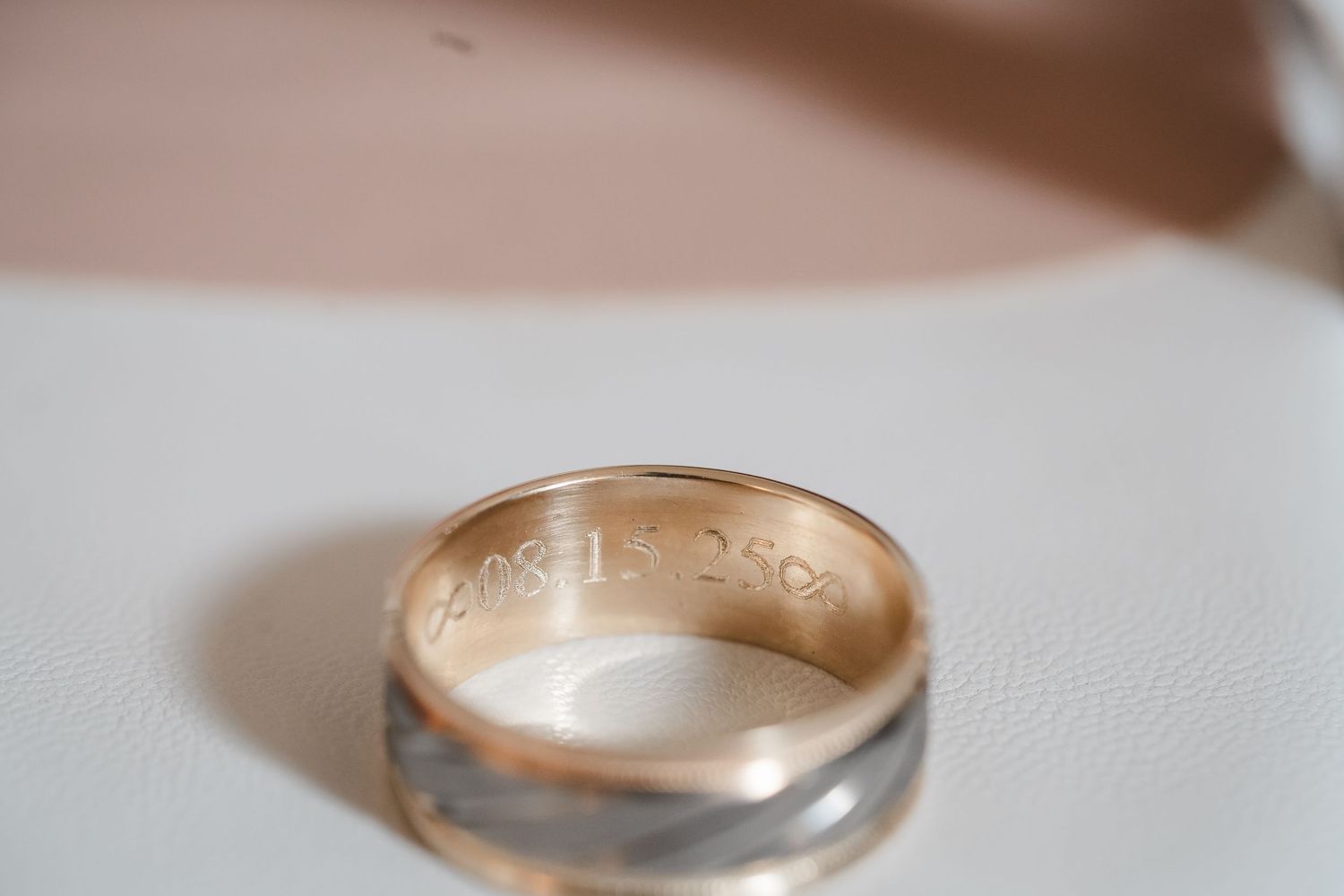 Wedding bands in rose gold and silver displayed in a minimalist style on white surface.