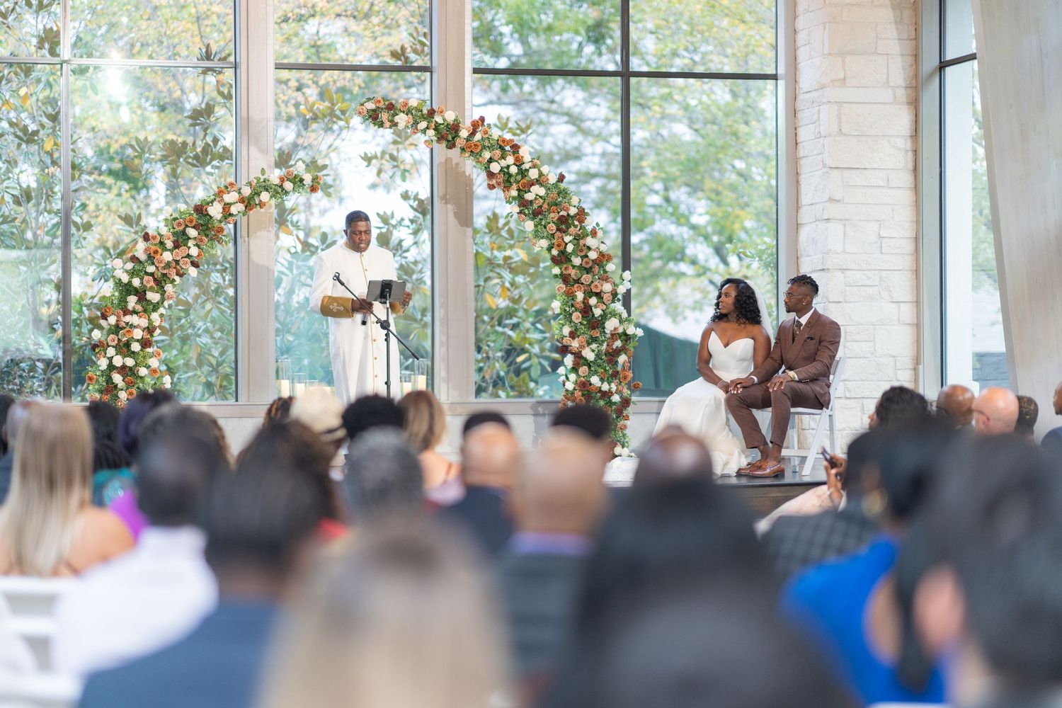 Wedding ceremony venue with floral arch and guests seated in rows.