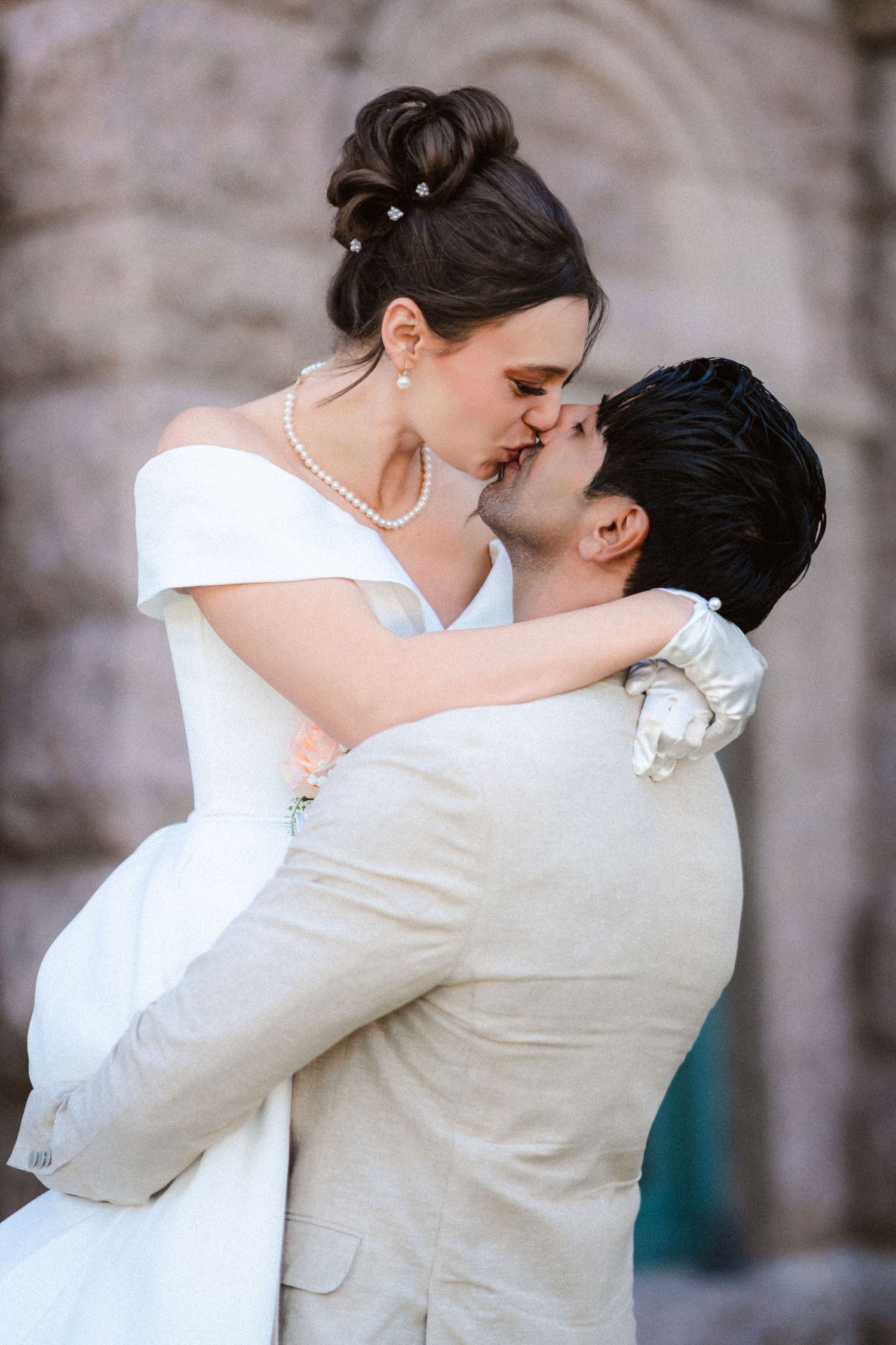 A tender moment between newlyweds as they embrace in their white wedding attire.