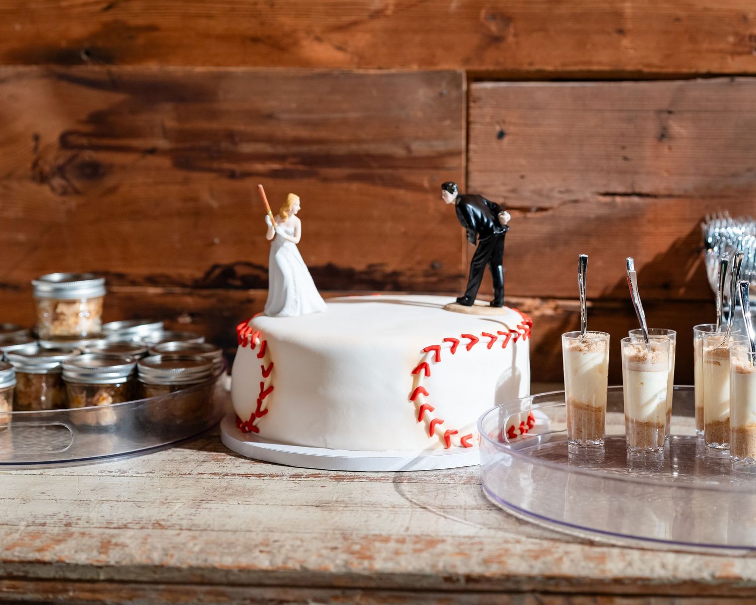 Vintage glass milk bottles with red and white striped paper straws arranged on a rustic wooden table.