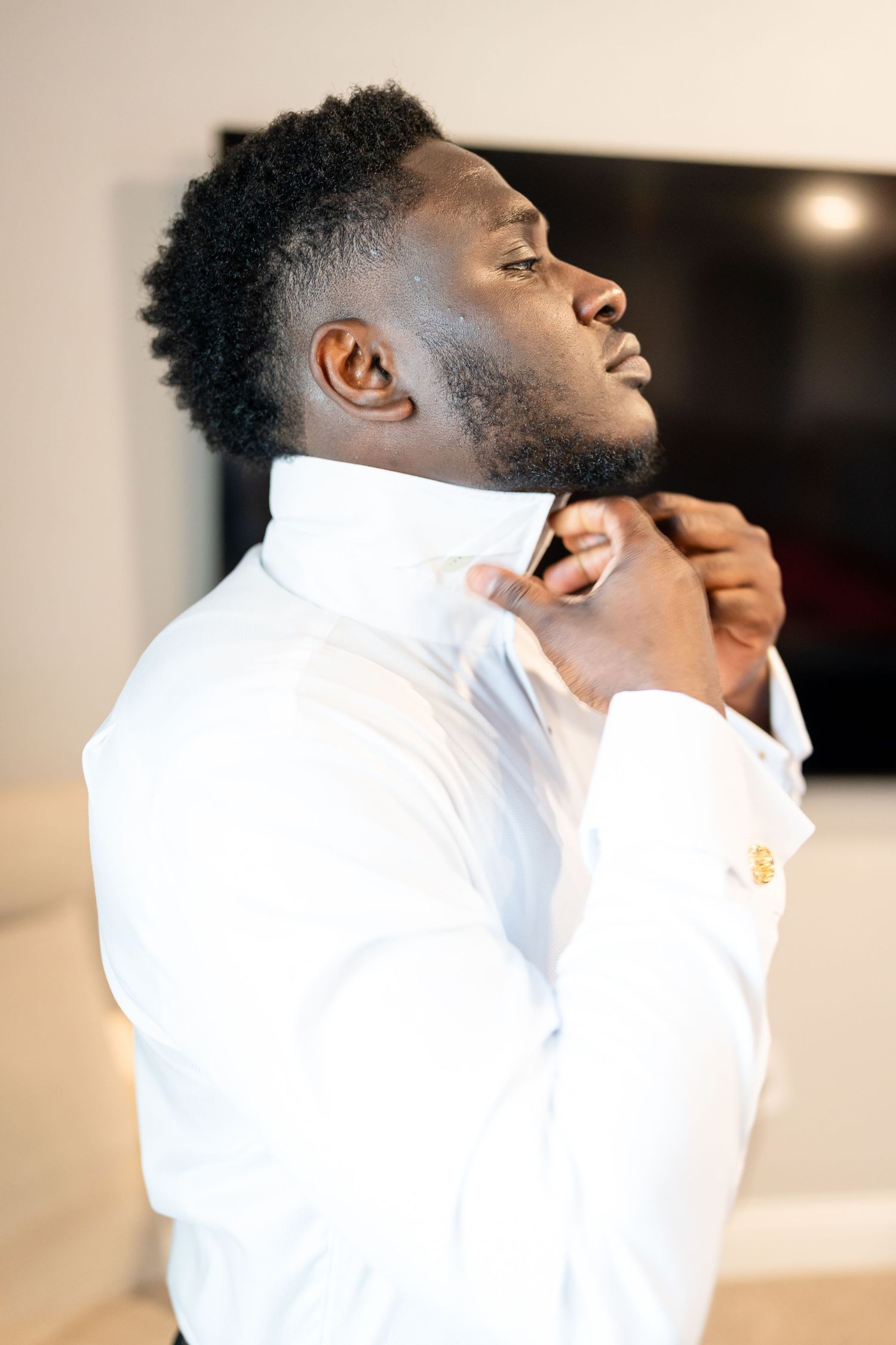 A person in a white dress shirt shown in profile against a light background.