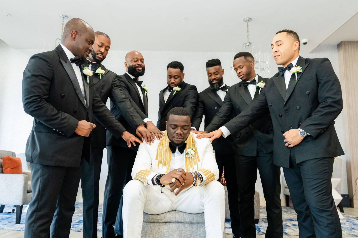 Groomsmen in black tuxedos gather for candid group photos.