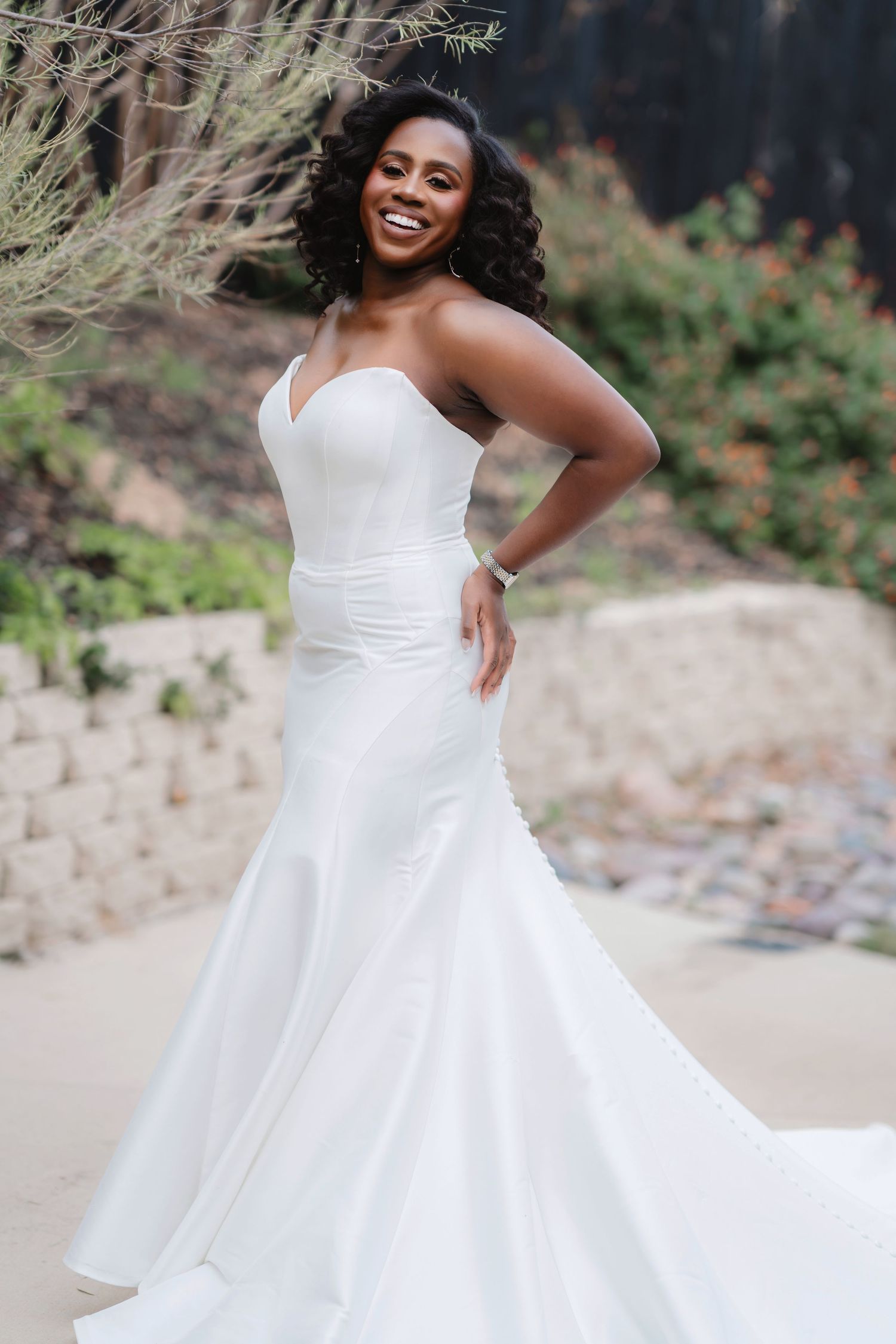 A beautiful white ballgown wedding dress twirls gracefully in an outdoor garden setting.