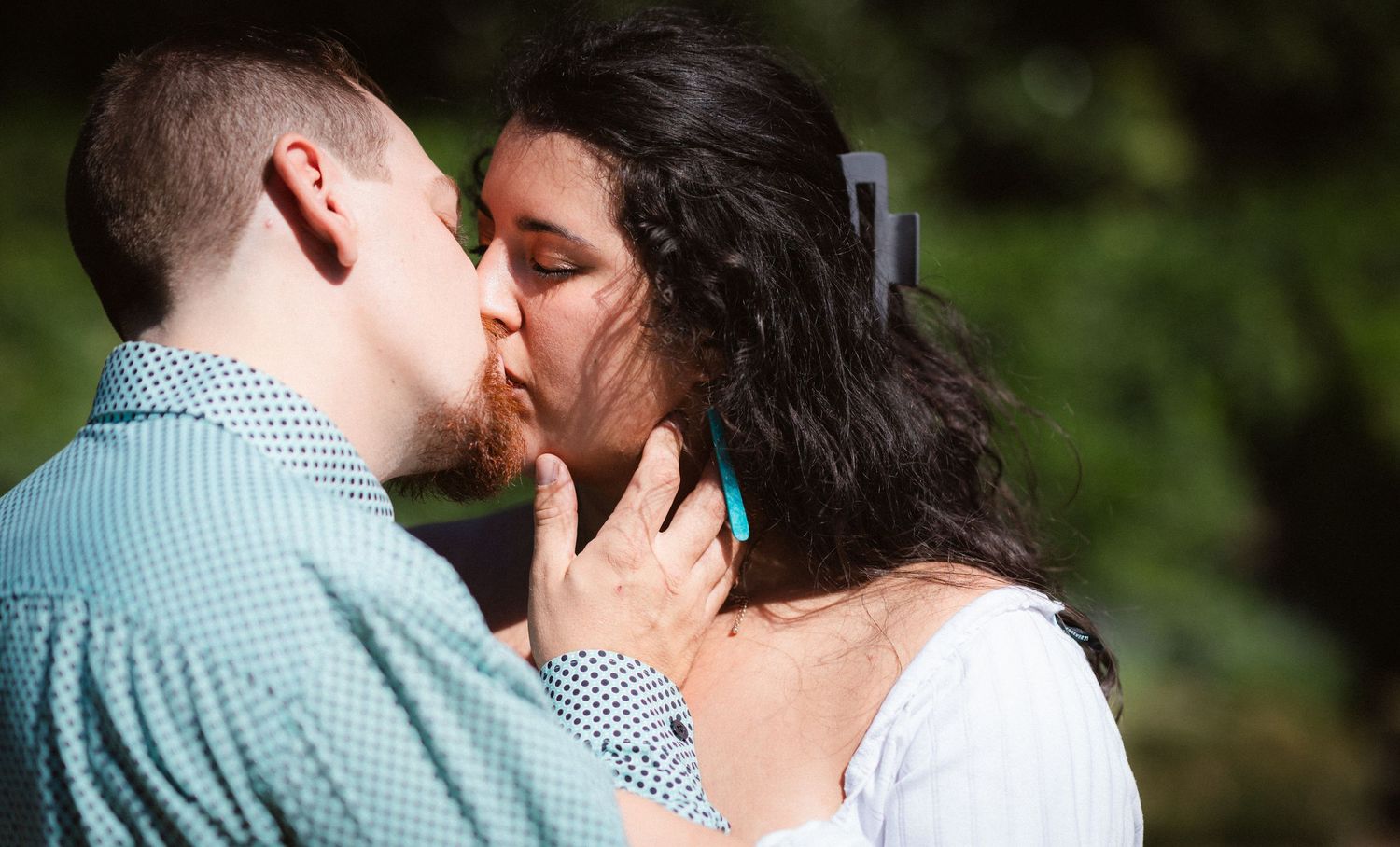 A tender romantic moment shared between a couple in a natural outdoor setting.