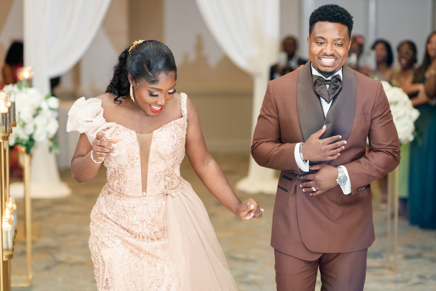 Celebratory moment during a wedding reception with guests dancing in formal attire.