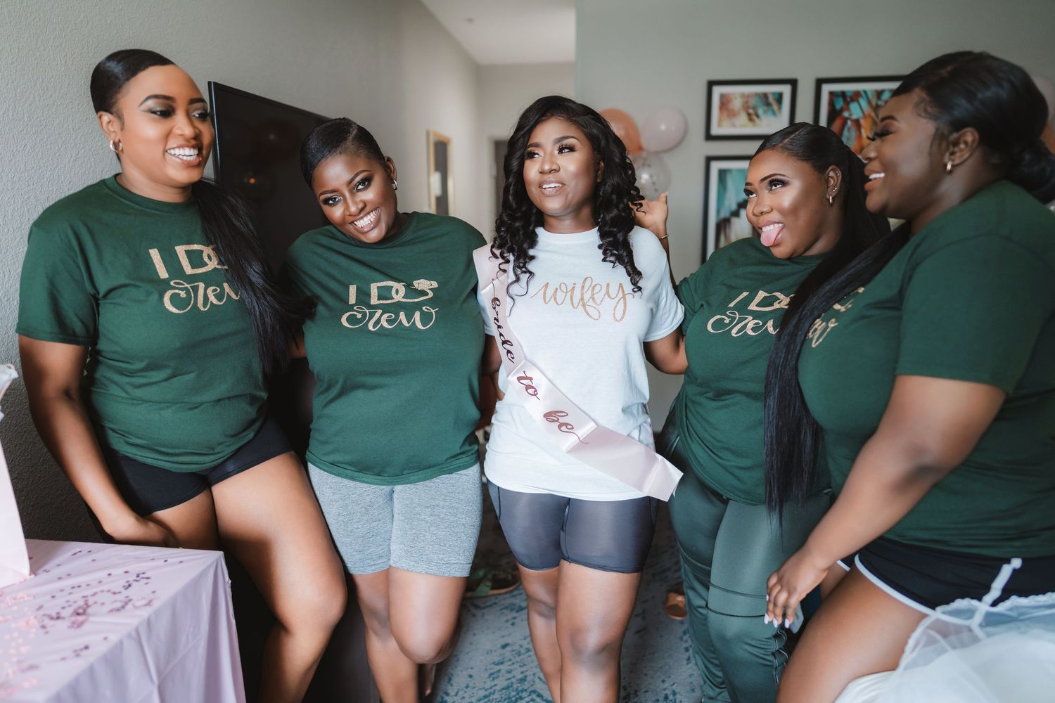 A group wearing matching green shirts share joyful moments during wedding preparations.