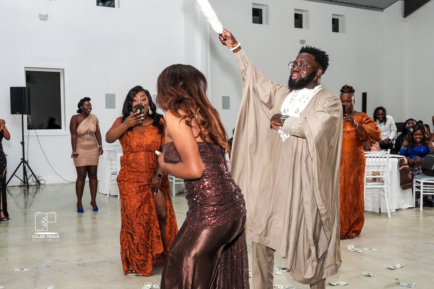 People dancing and socializing at a casual indoor gathering in a bright white studio space.