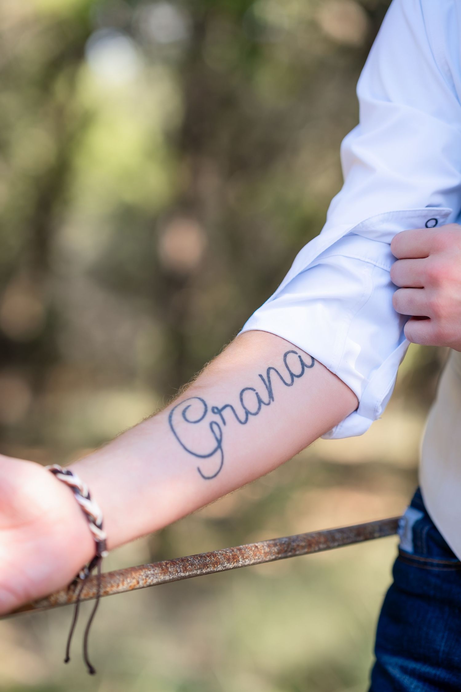A close-up of a cursive 'Grana' tattoo on someone's forearm.