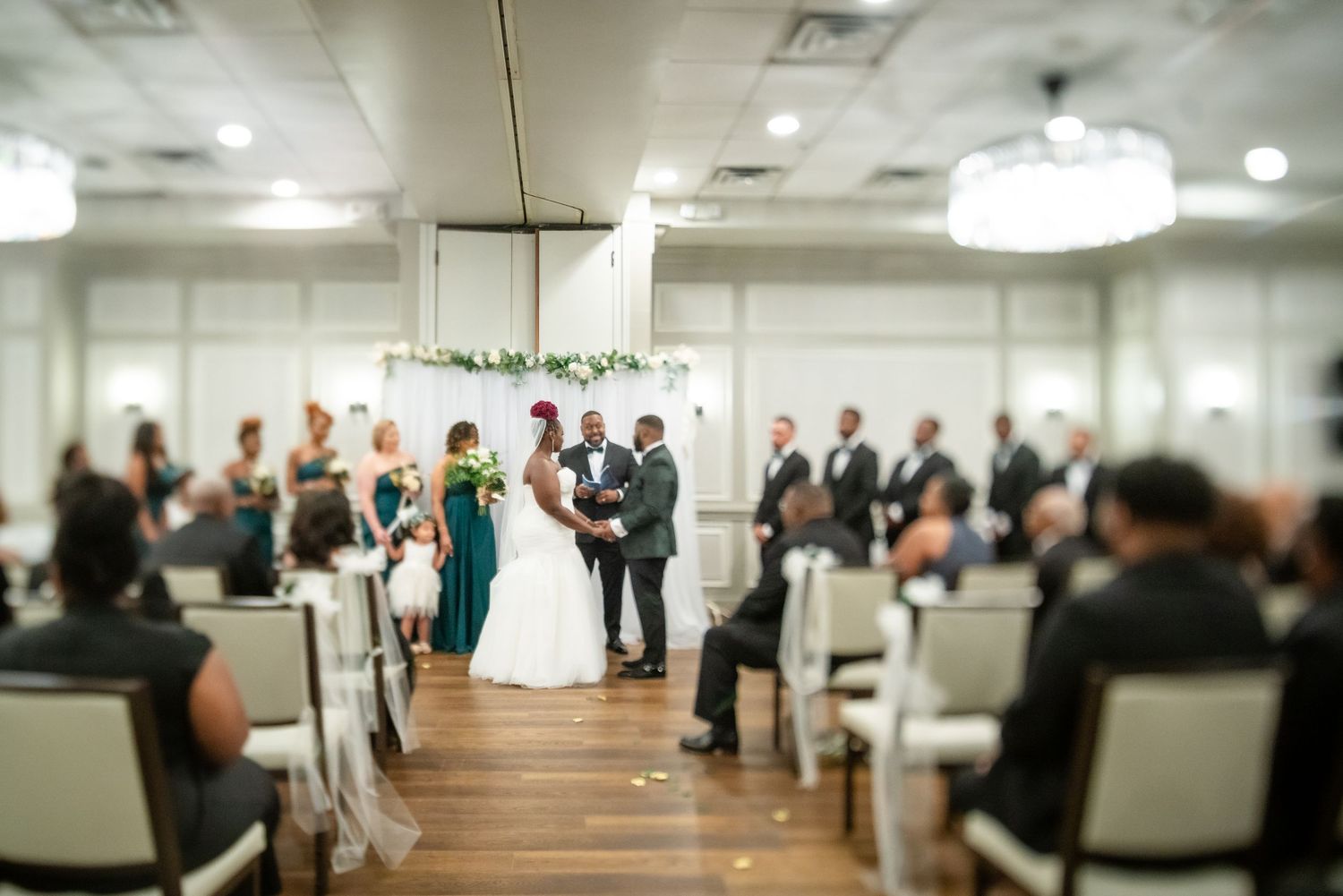 Modern reception hall setup with chairs and ambient lighting for a wedding celebration.