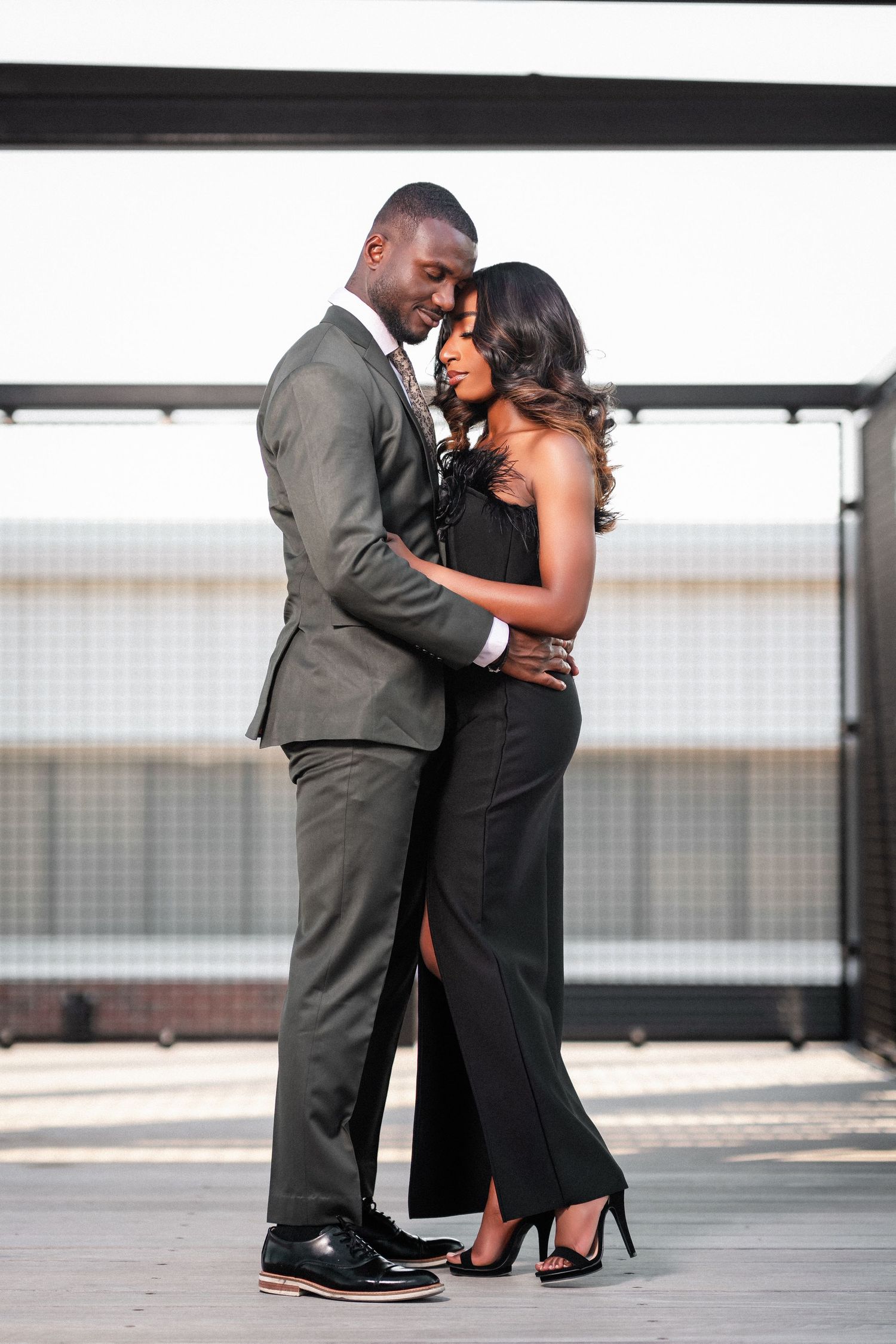 Elegant couple shares intimate moment during outdoor portrait session.