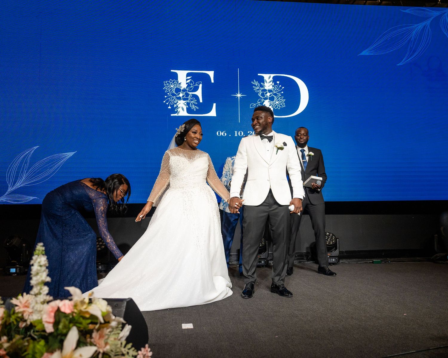 Wedding reception venue features blue lighting and elegant white decor elements.