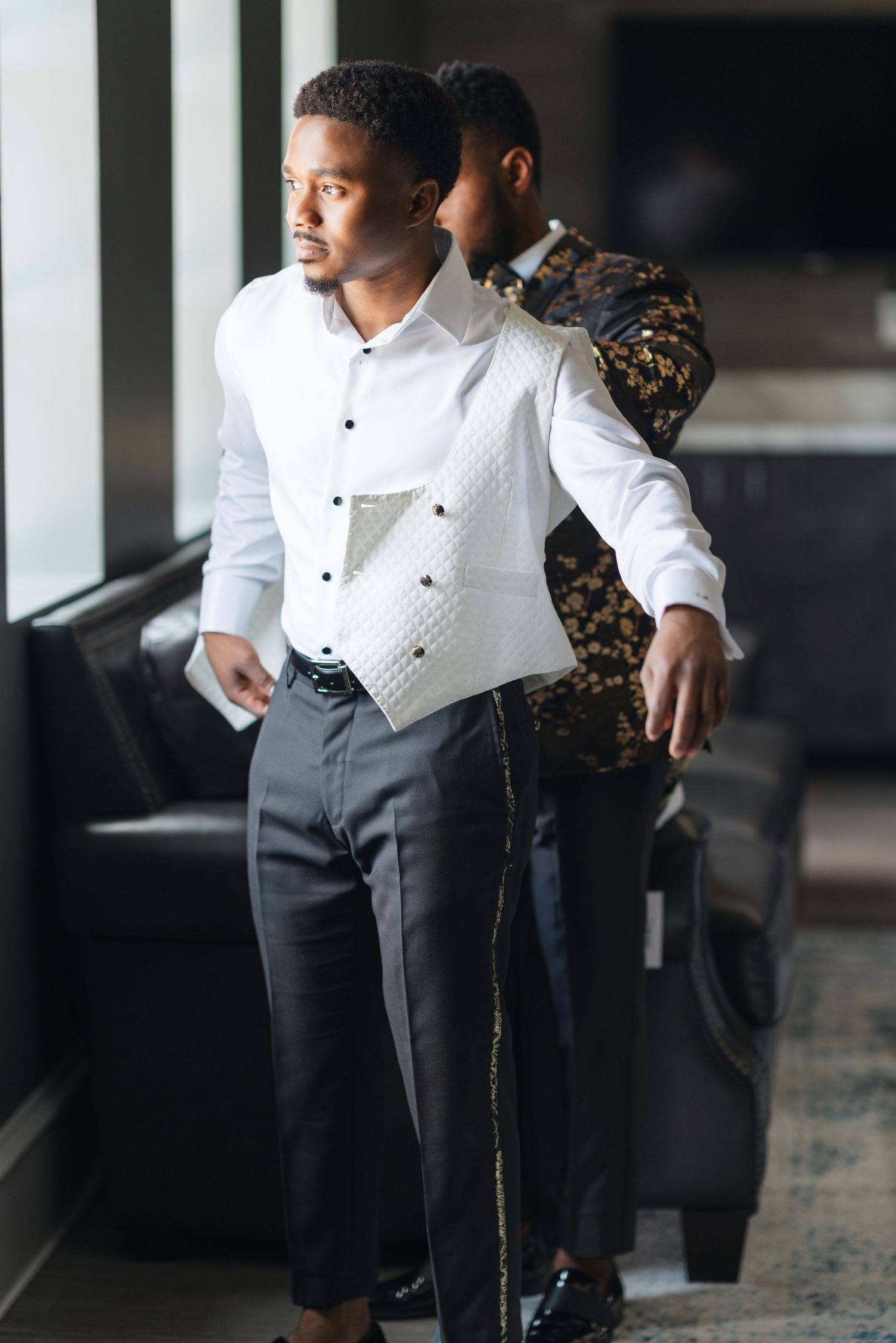 Formal attire details showing white dress shirt and black pants in an indoor setting.