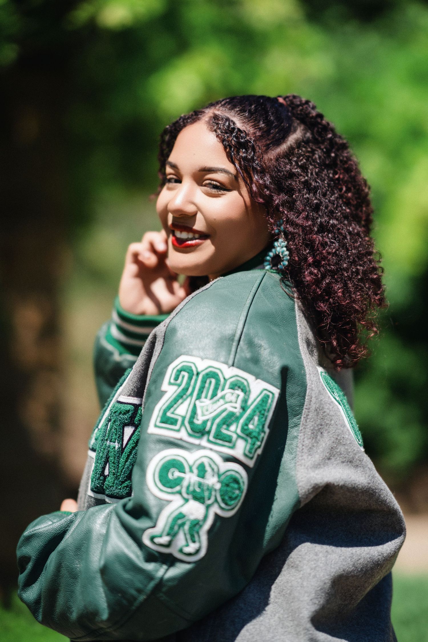 A series of candid shots showing someone wearing a green and grey varsity jacket while smiling outdoors.