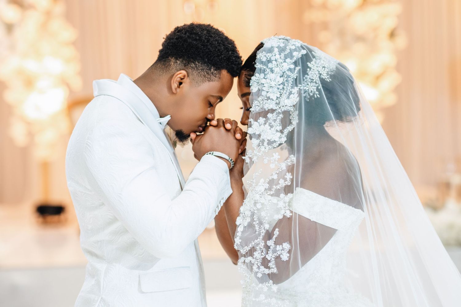 Tender wedding moments captured between bride in lace veil and groom in elegant formal wear.