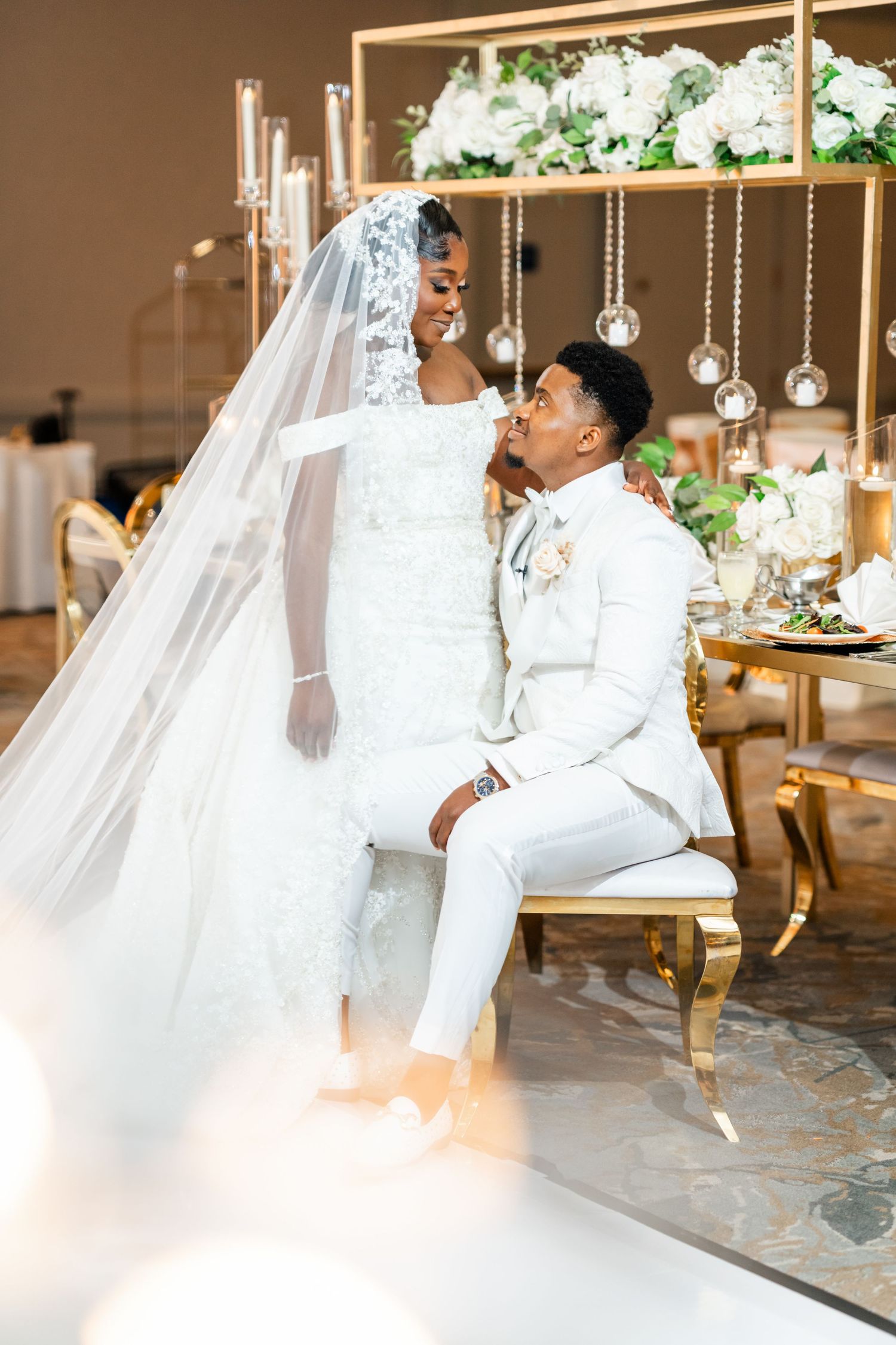 Elegant wedding photoshoot with hanging crystal decorations and luxurious seating.