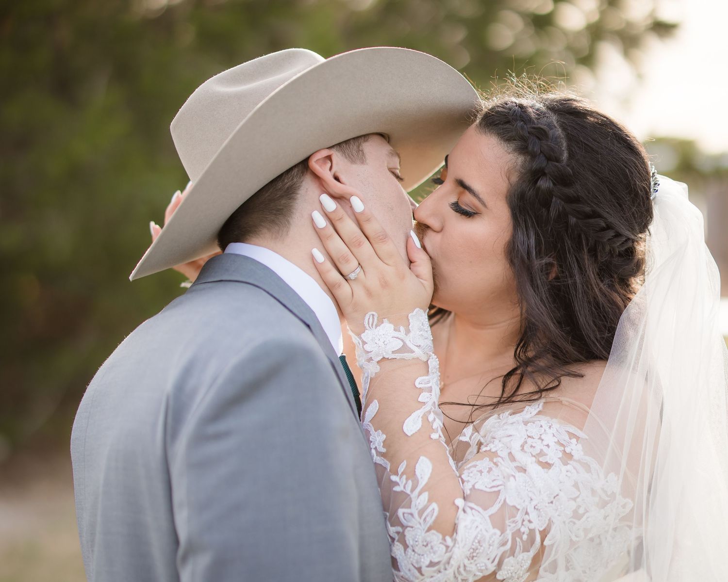 A romantic wedding photo series showing tender moments between a couple in western attire against a natural backdrop.