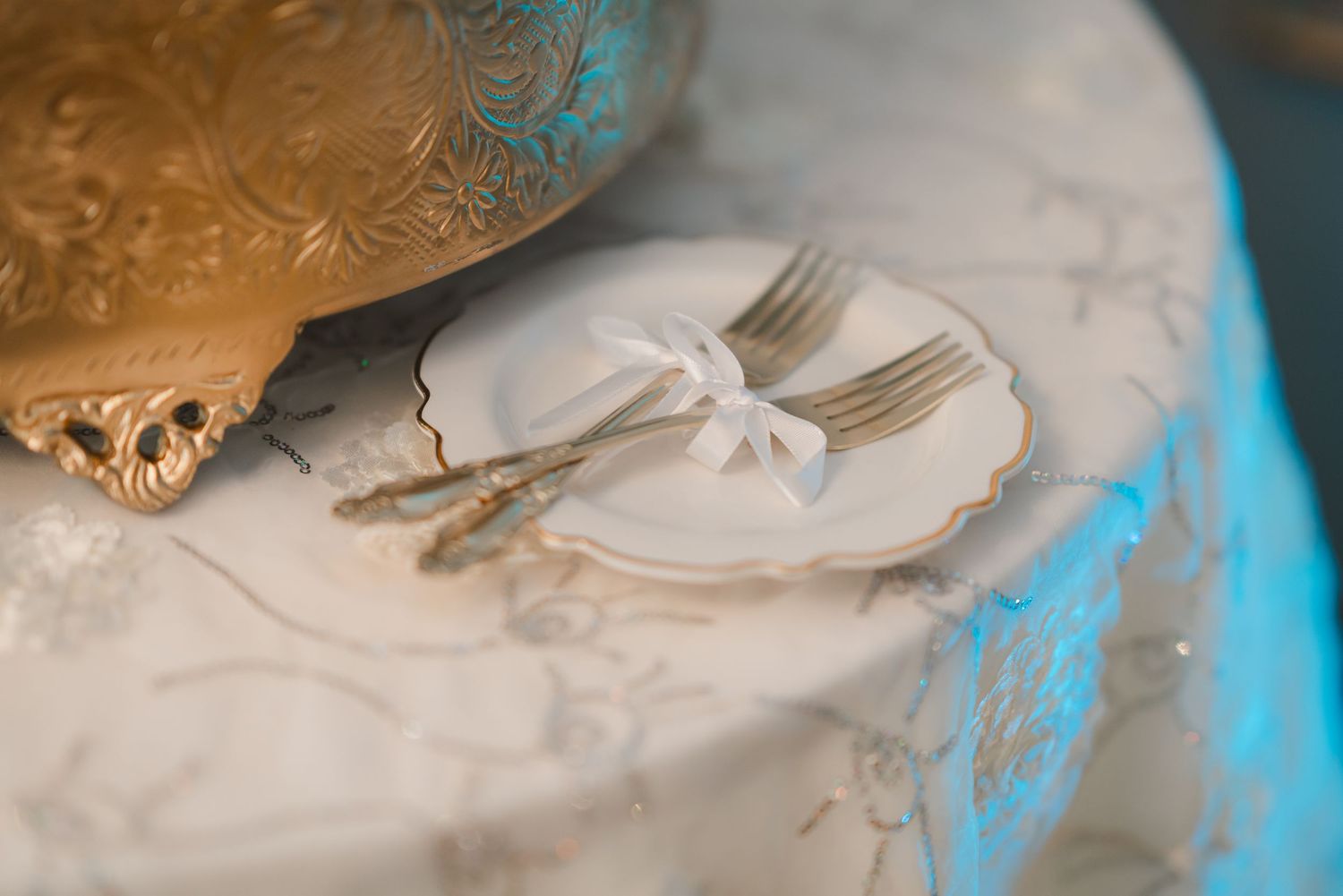 Close-up detail of elegant place settings with silver cutlery and white napkins at a formal event.
