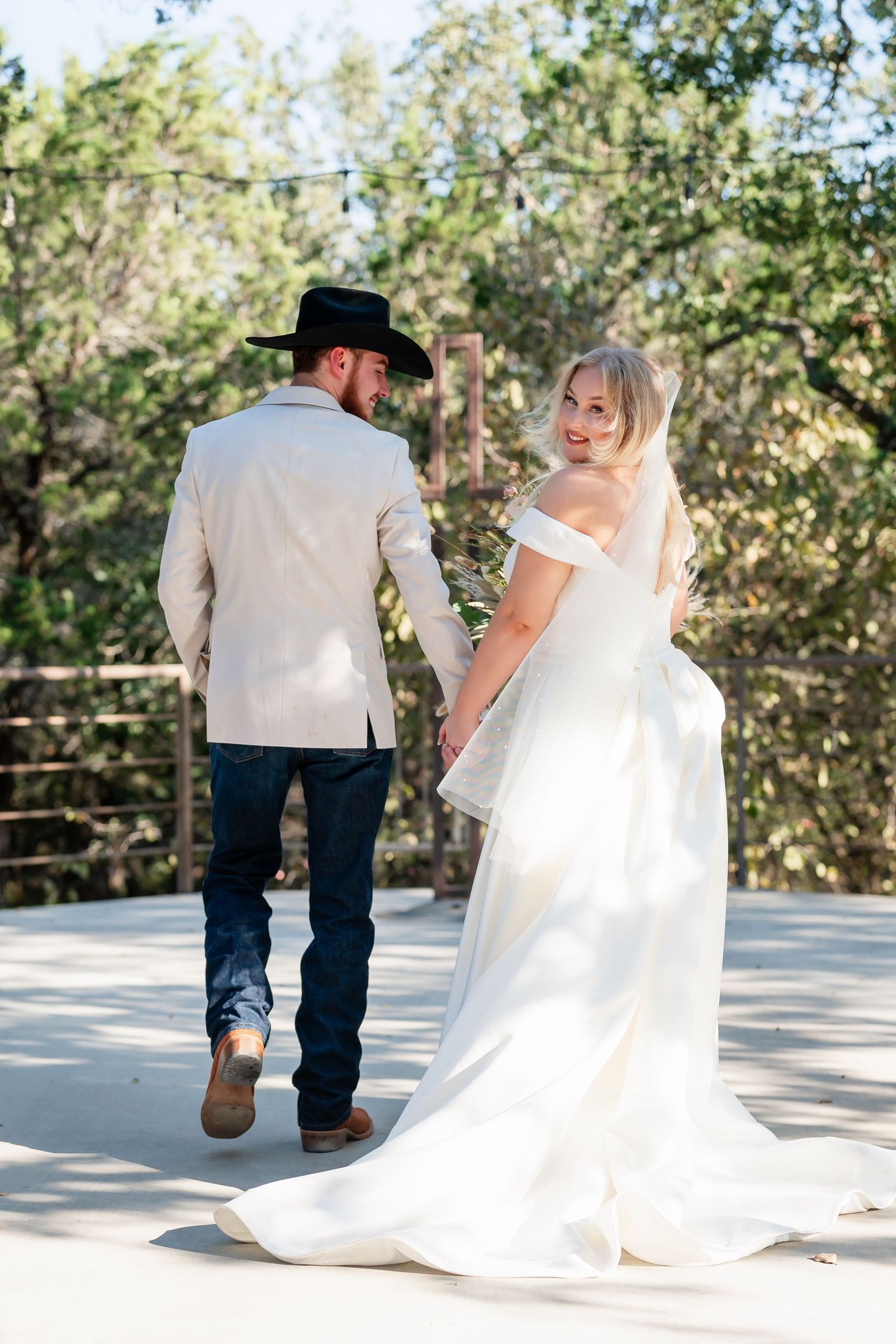 Romantic wedding photos on an outdoor deck showing flowing white dress and cowboy boots.