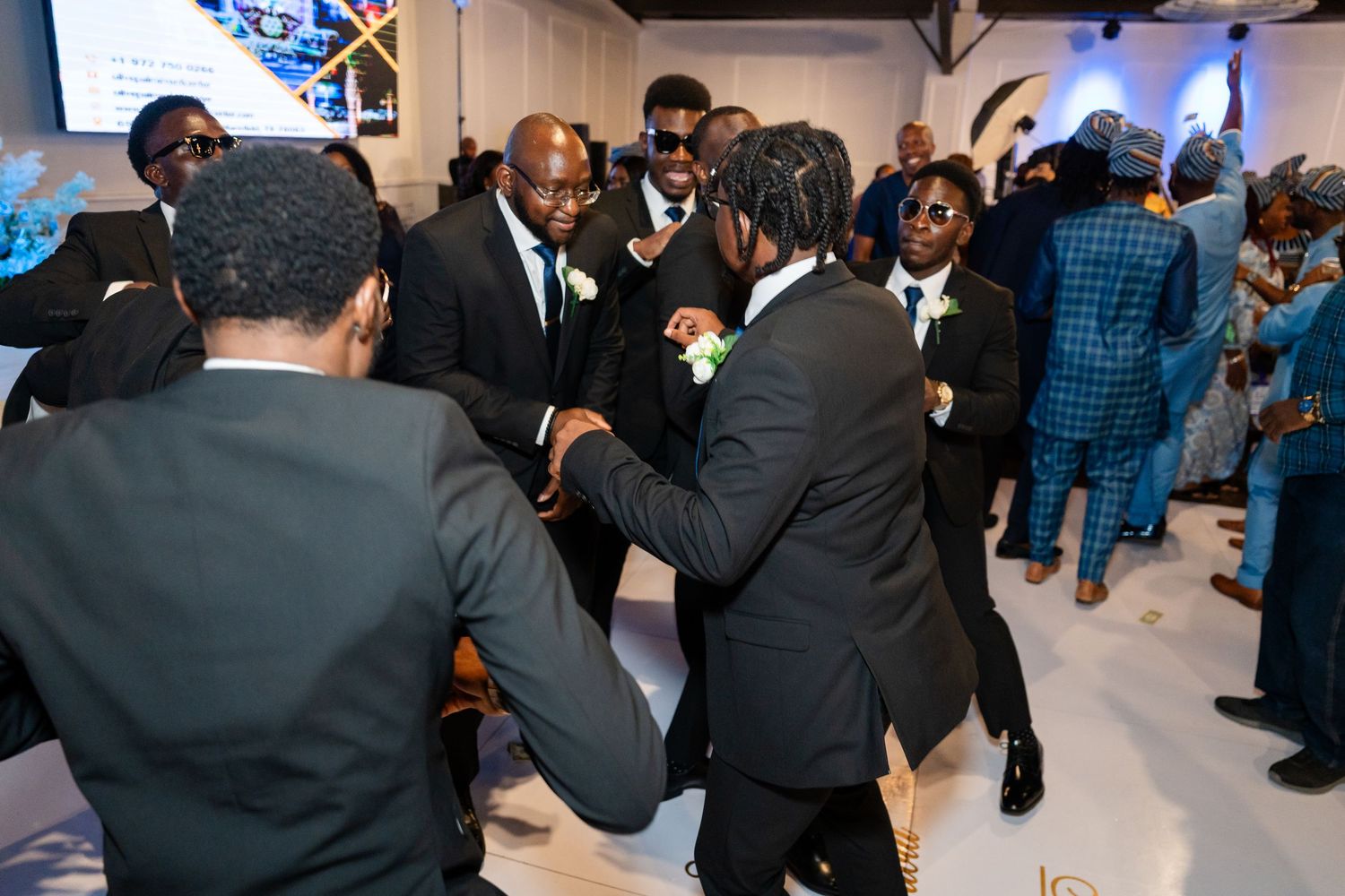 Lively dance floor scene at wedding reception with guests enjoying the celebration.