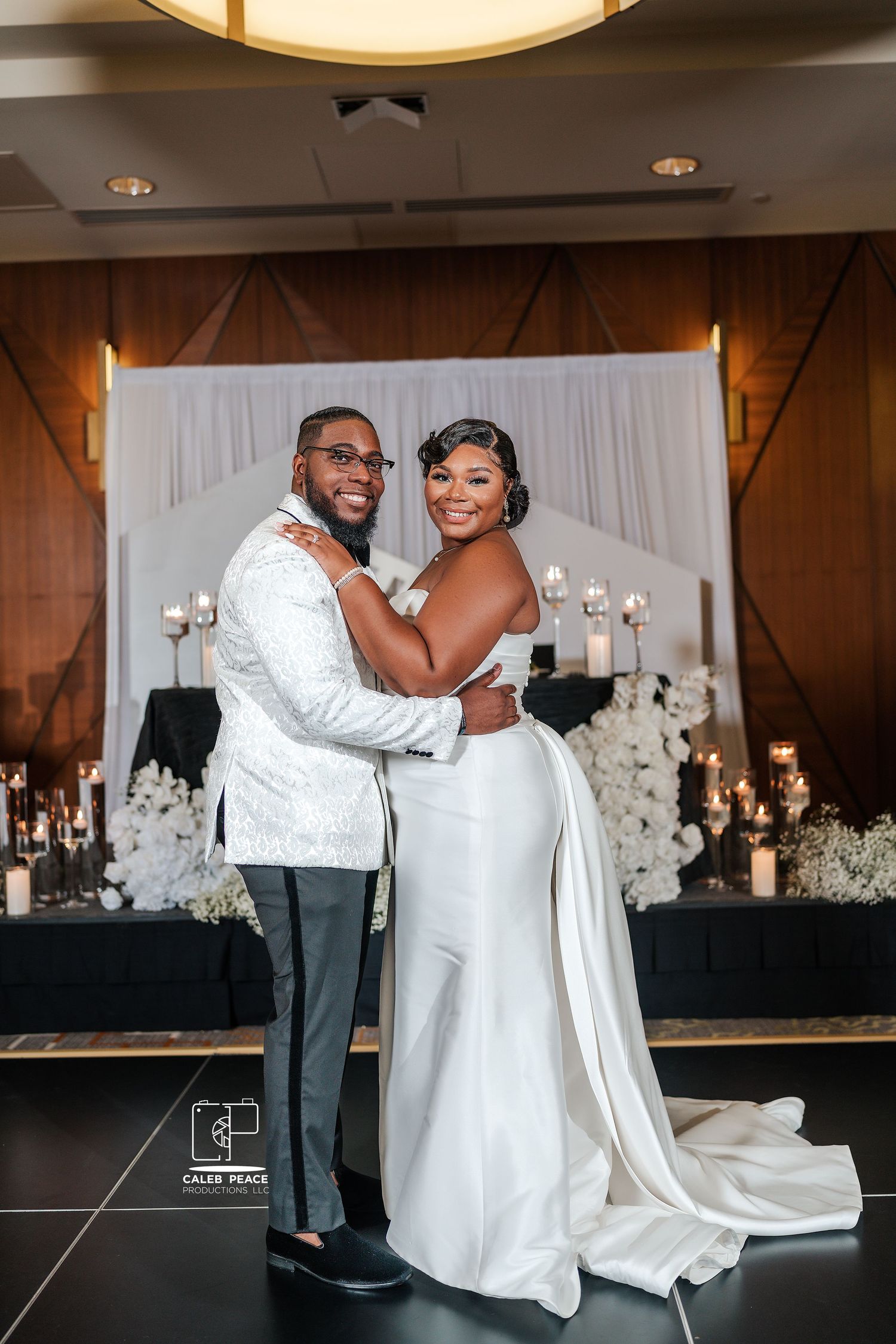 Elegant wedding reception setup with white decor, floral arrangements, and a romantic first dance moment.