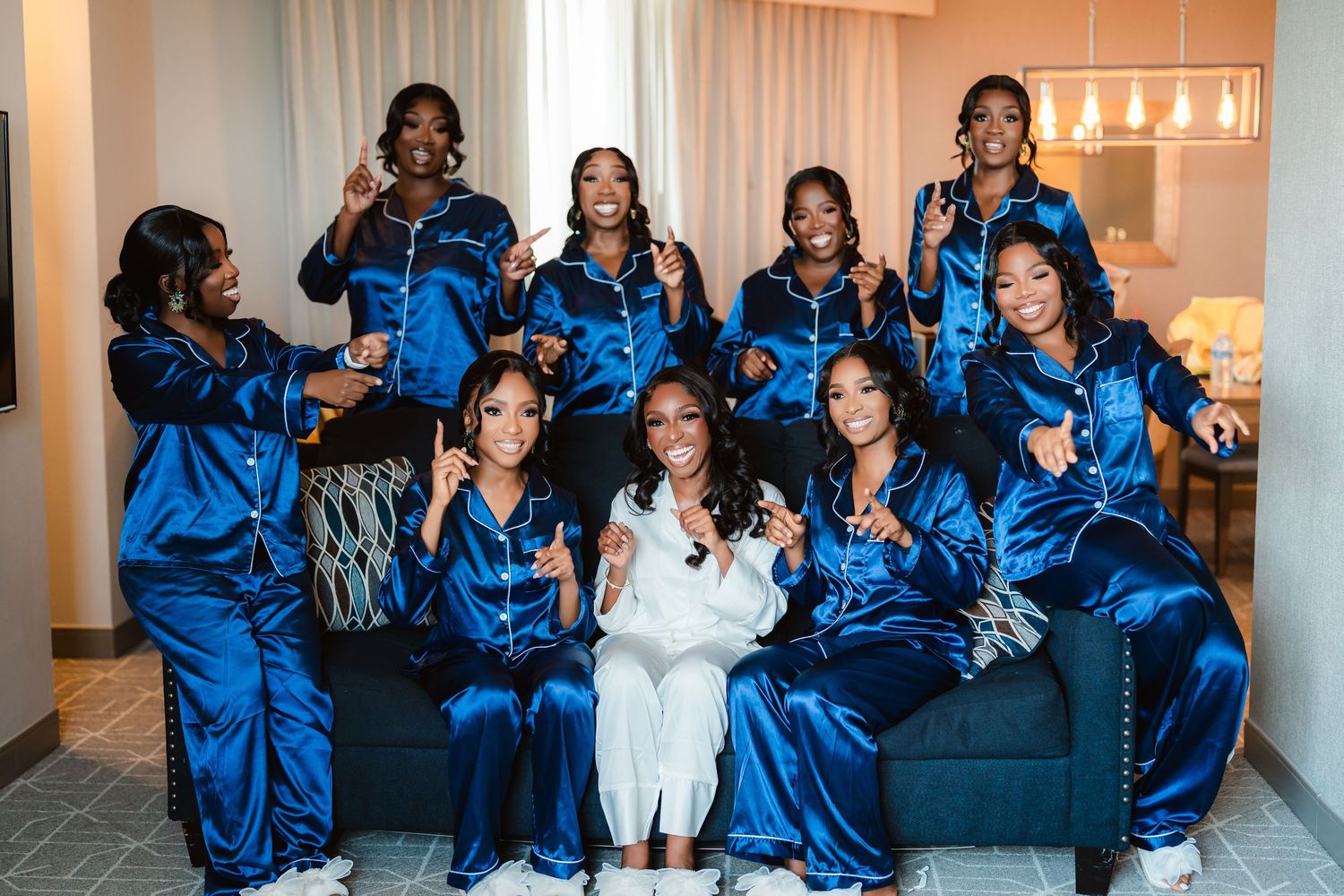 Wedding party in royal blue satin robes posing together for photos.