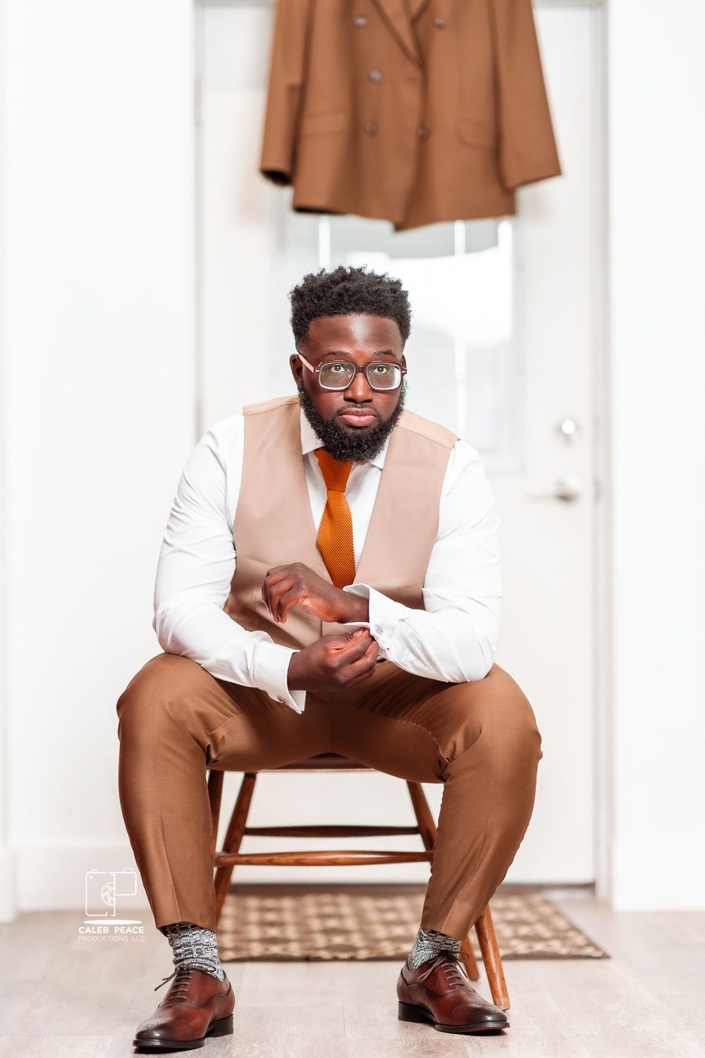 Professional portrait series showing stylish brown and white suit combination with orange tie against white backdrop.