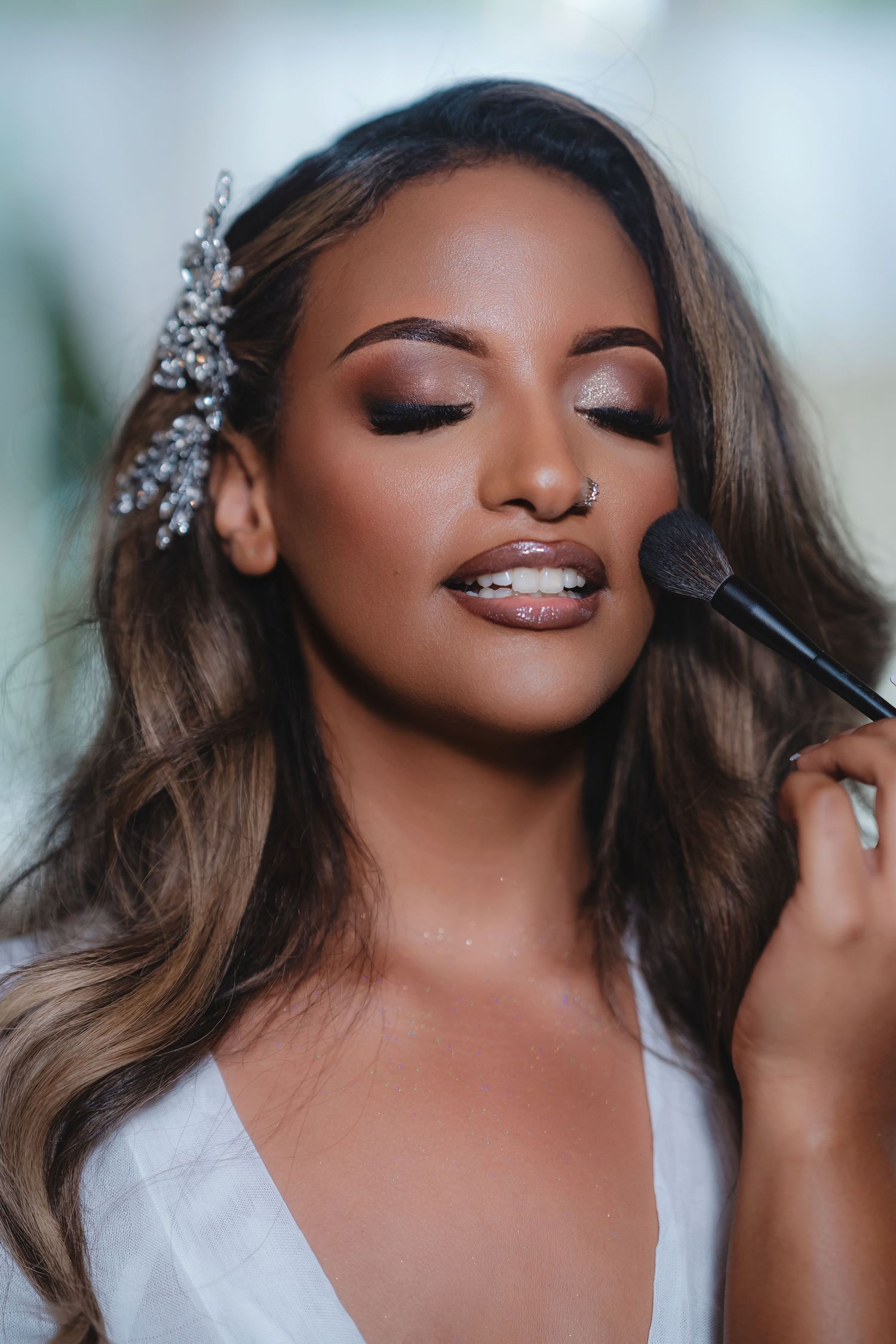 Close-up shots of professional makeup application with shimmering eyeshadow and crystal hair accessories.