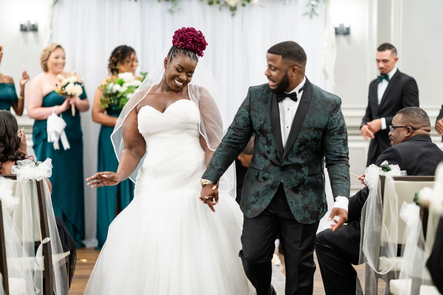 Joyful newlyweds celebrate while walking down the aisle at their wedding ceremony.