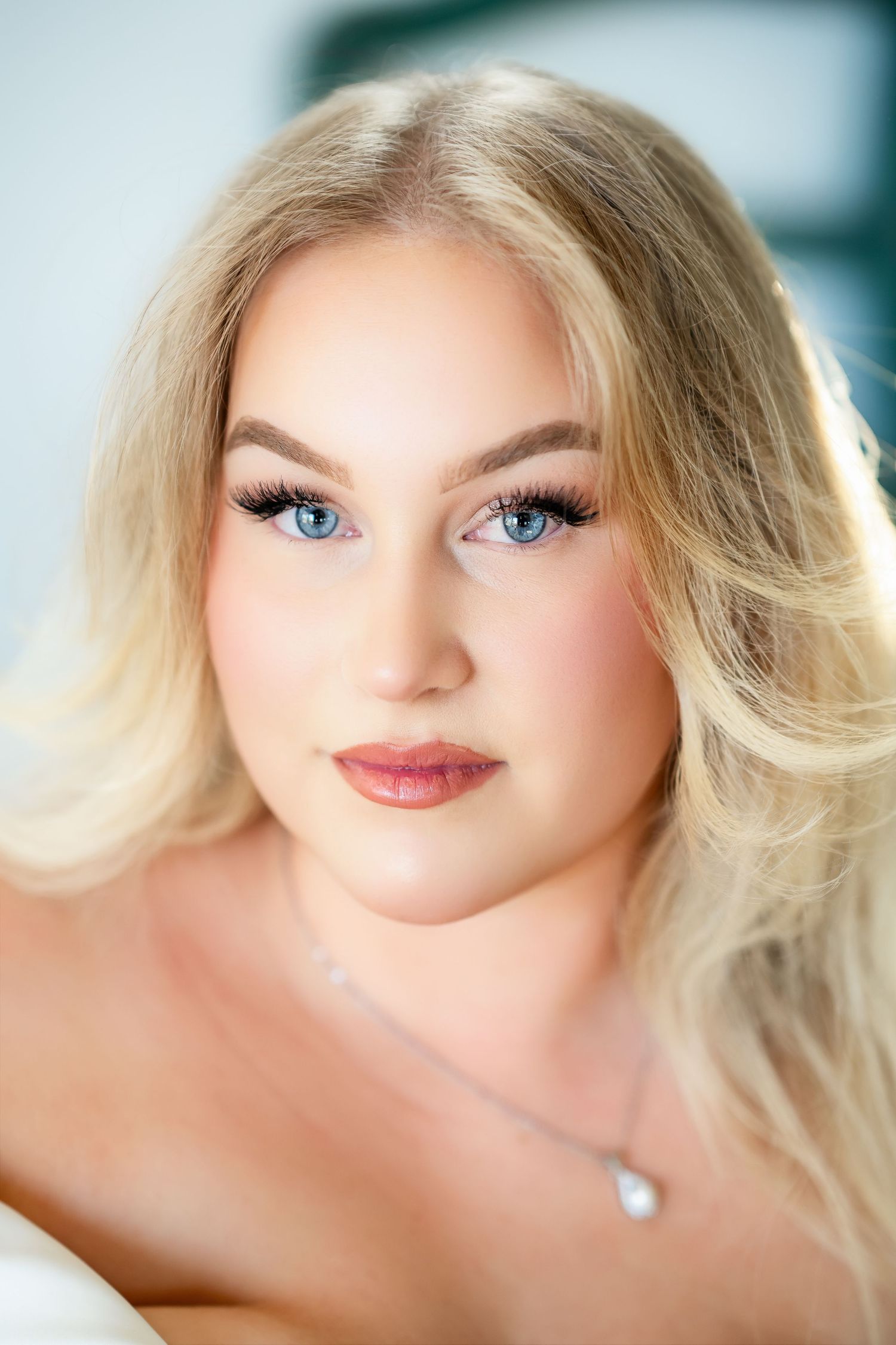 Soft focus beauty portrait with natural makeup and pearl necklace.
