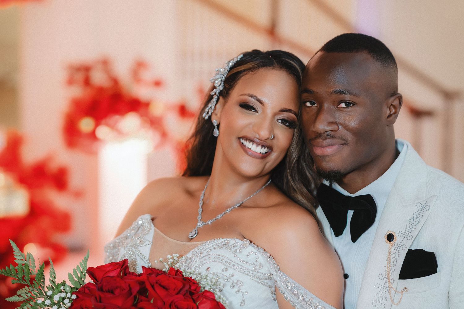 A romantic wedding photo series showing a couple in formal attire with vibrant red floral decor in the background.