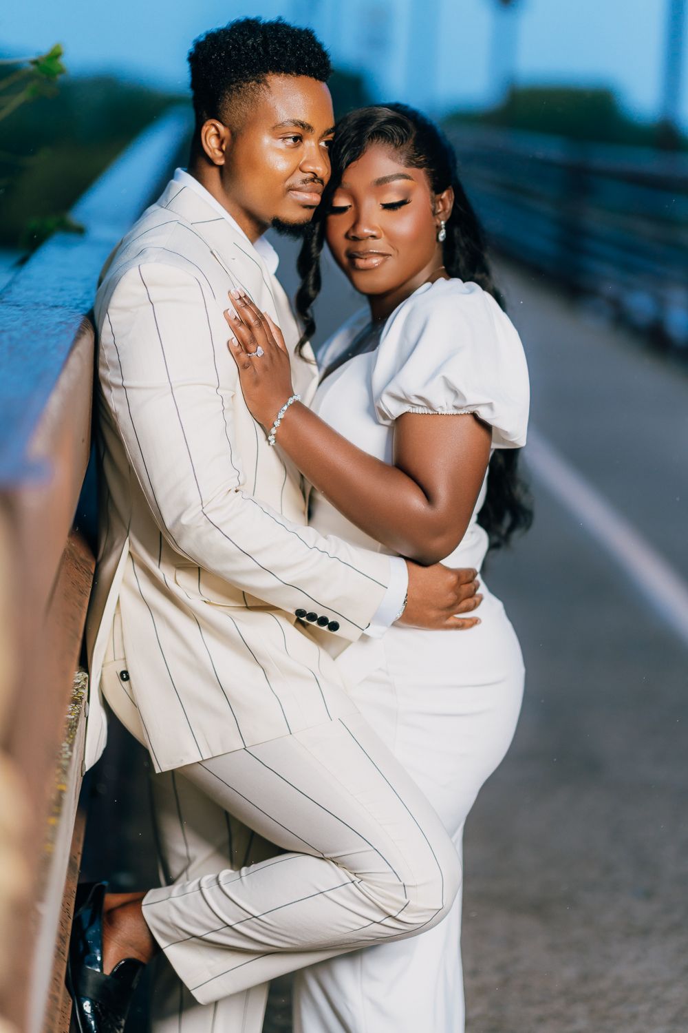 Loving couple embraces on a bridge during their evening photoshoot.