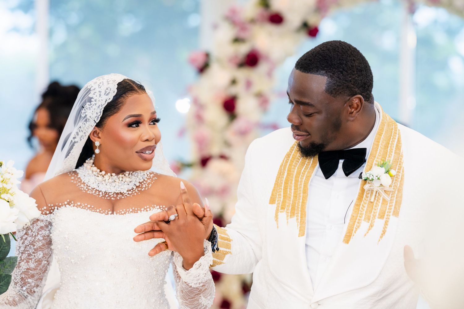 Wedding ceremony scene with floral decor and white and gold color scheme.