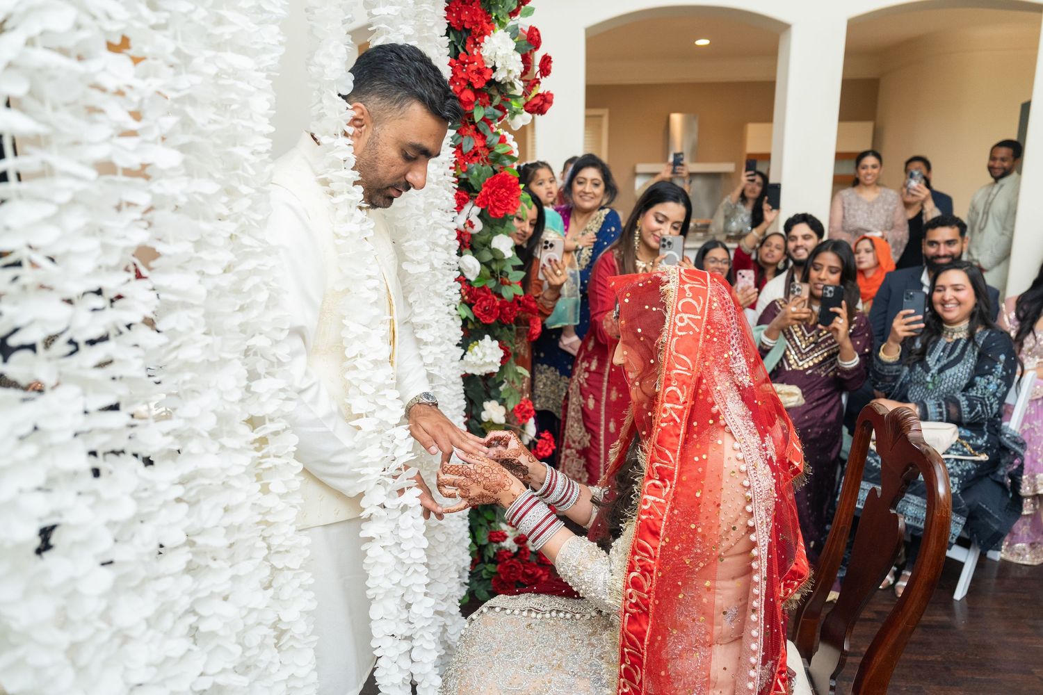 Wedding ceremony setup with cascading white floral decorations and red roses.