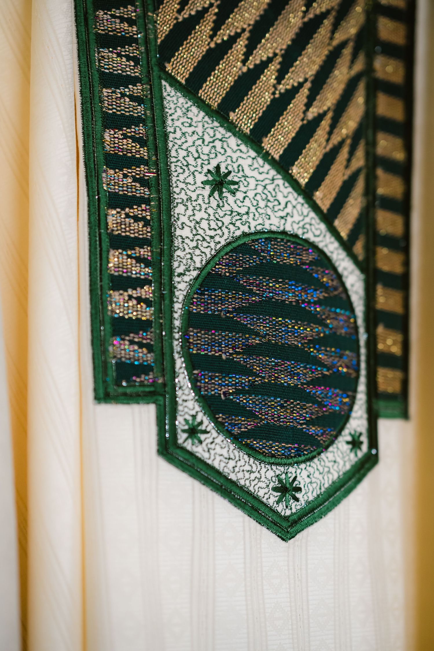 Detailed shots of an embroidered green and silver traditional Nigerian agbada neckline design.