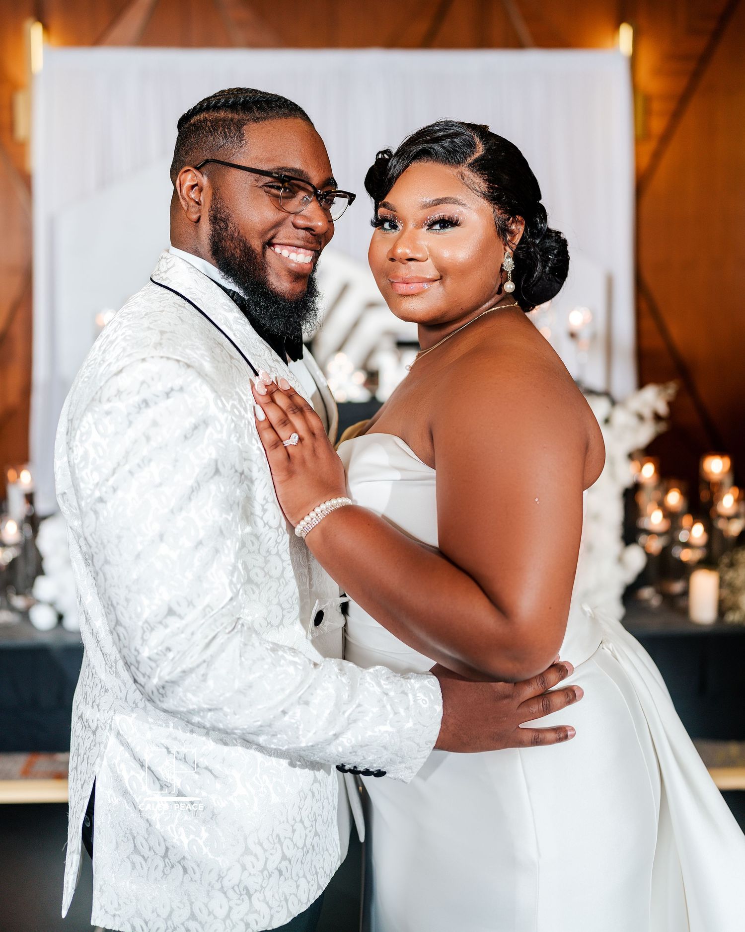 Romantic wedding moment captured in an indoor venue with white and gold decor.