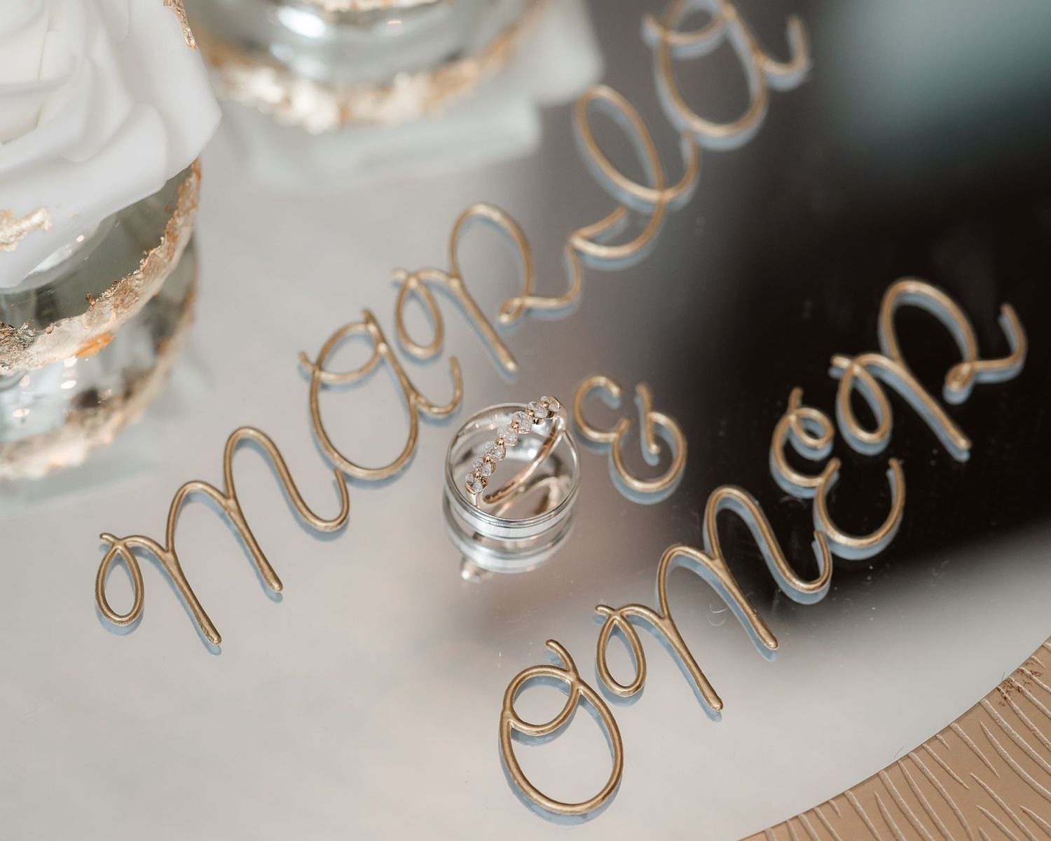 Close-up macro shot of elegant cursive text engraved on a shiny metallic surface with blurred background.