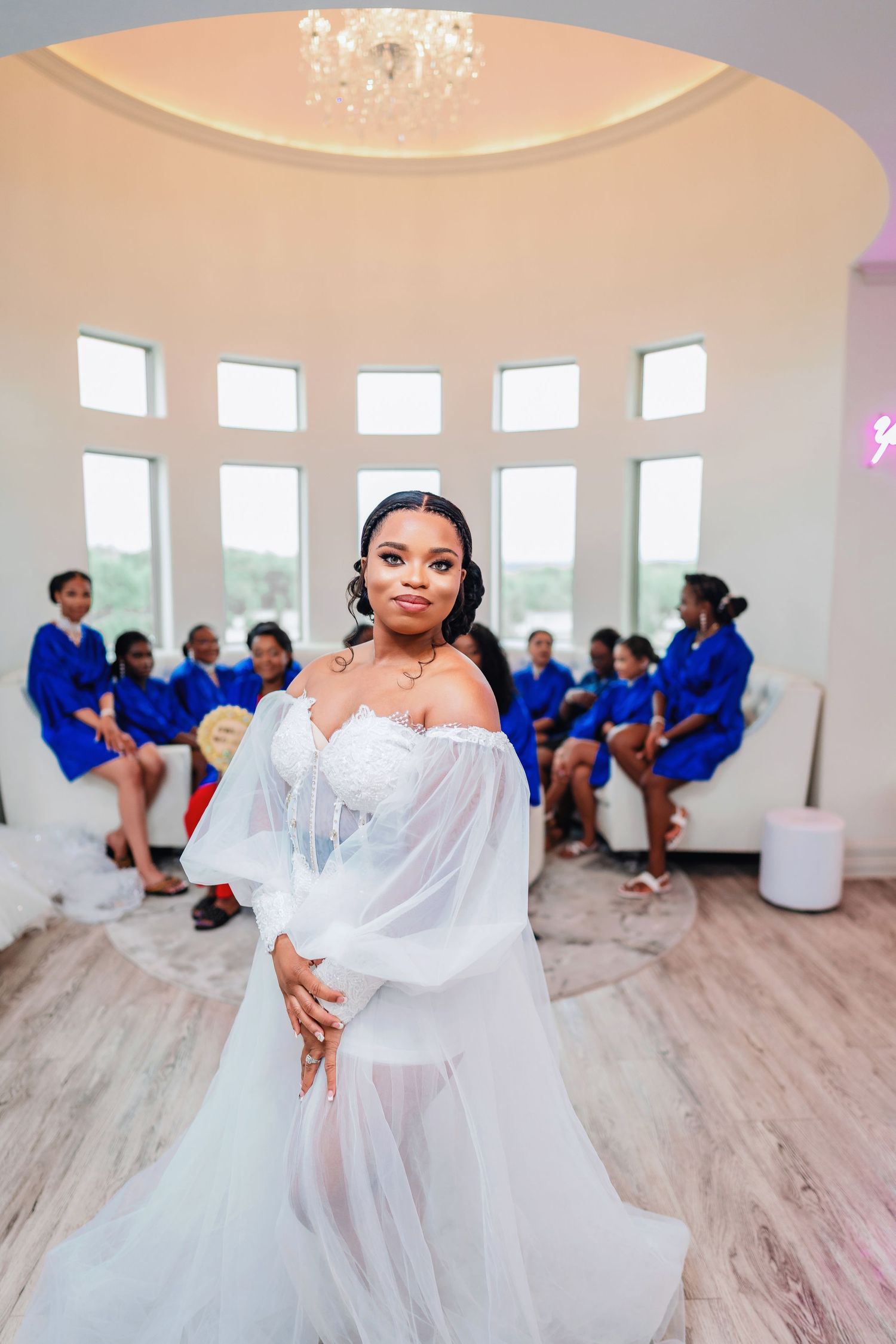 A beautiful wedding scene in a bright room with bridesmaids wearing royal blue dresses.