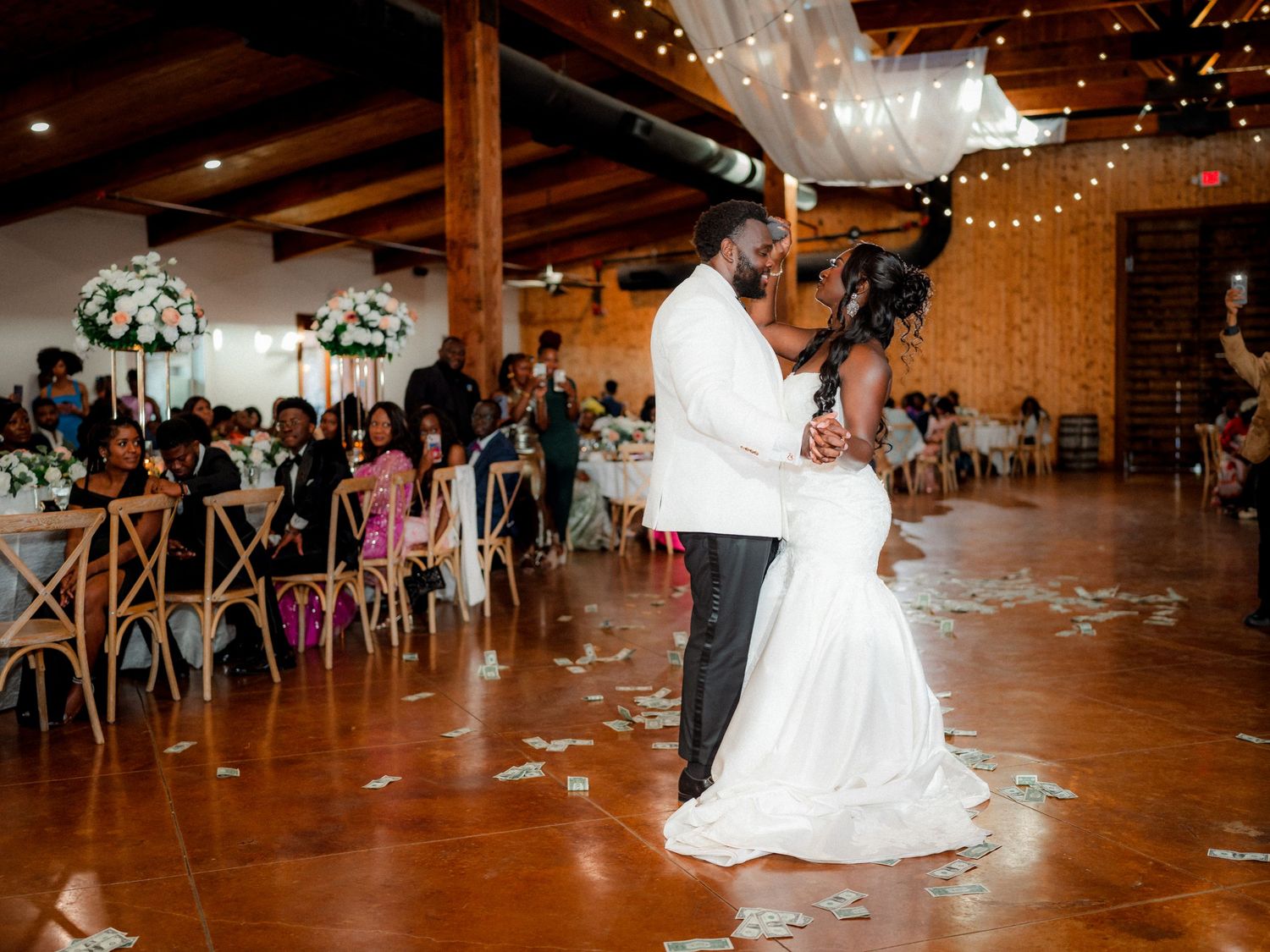 Wedding celebration captured in dynamic dance floor shots with white decor and string lights.