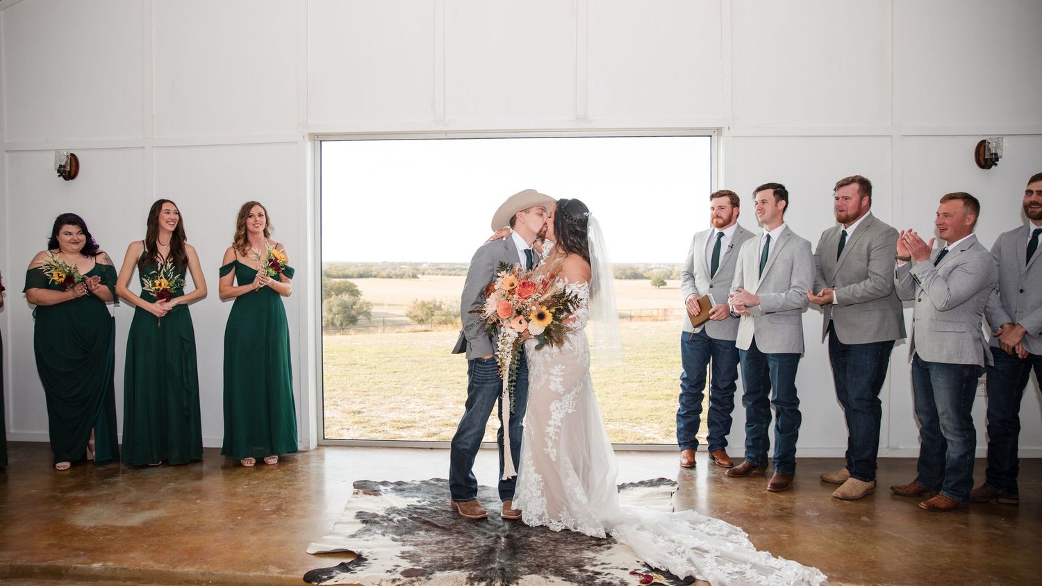 Panoramic view of a rustic wedding ceremony setup in a white indoor venue.