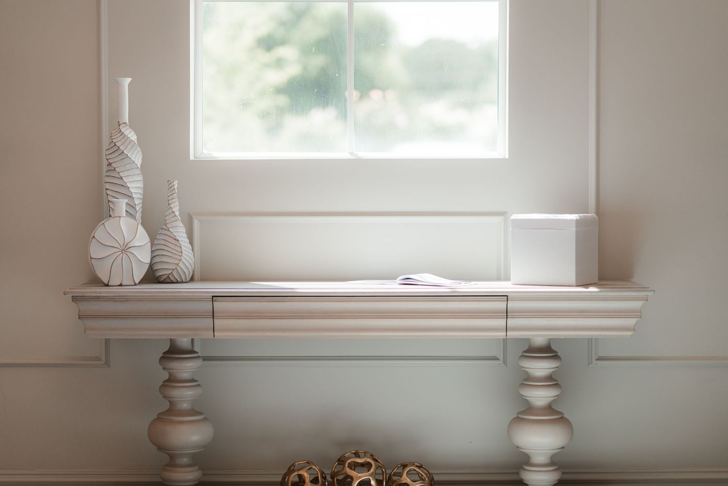 Minimalist white wedding venue interior with large windows and decorative vases.