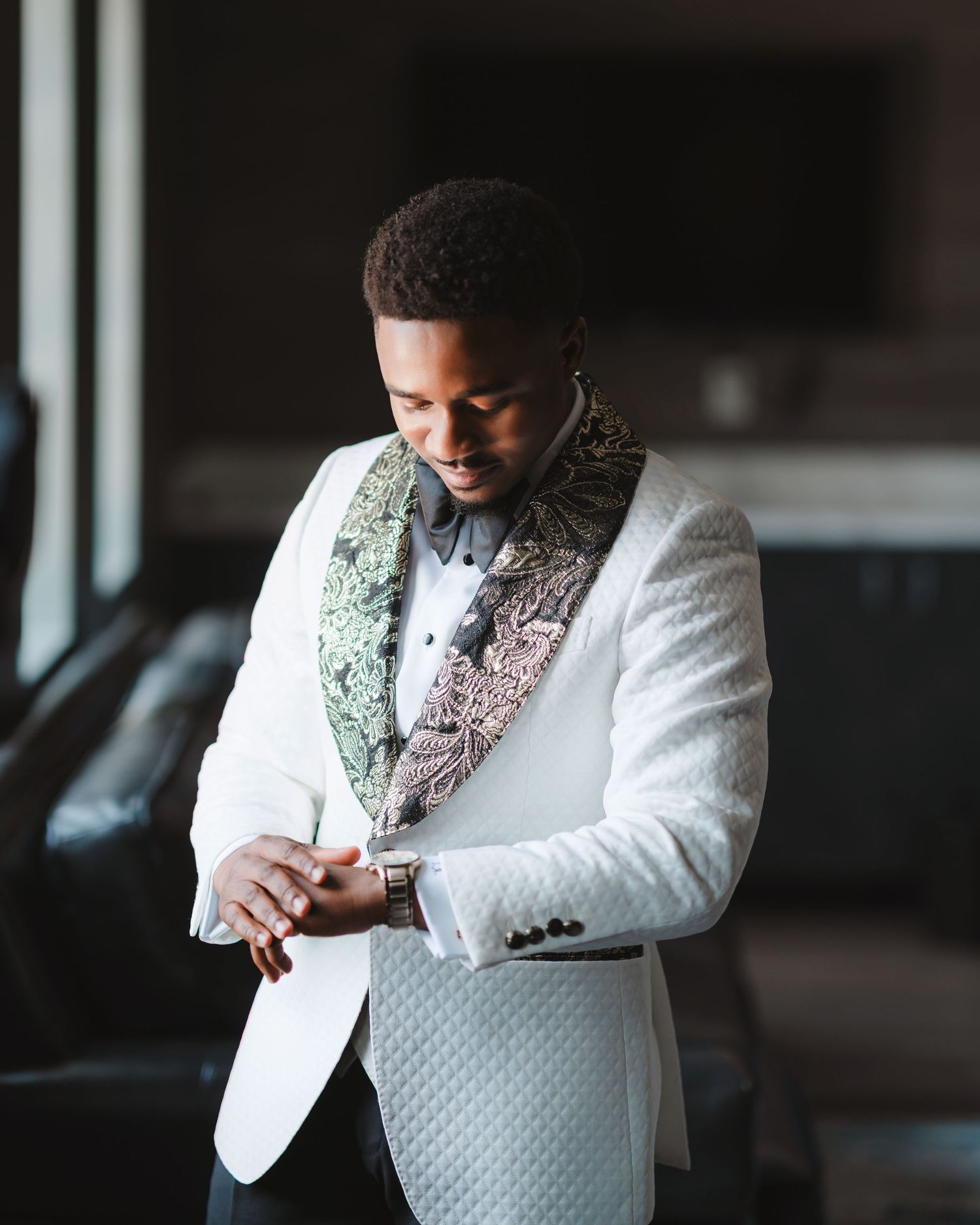 Close-up shots of a formal white tuxedo jacket with textured pattern and black bow tie.