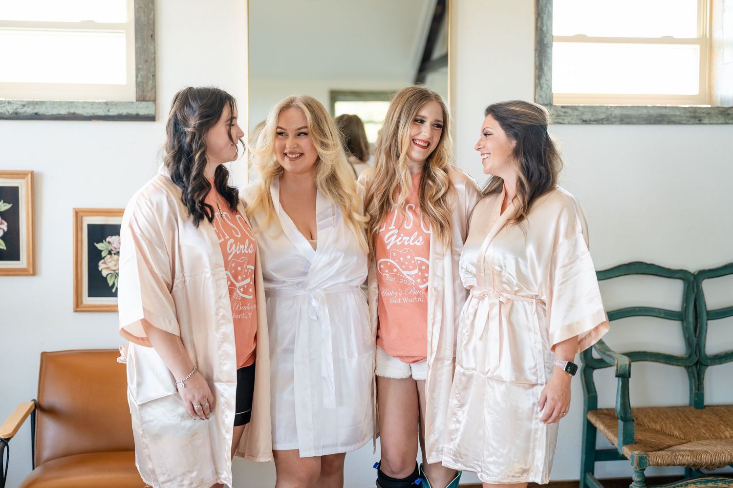 A group wearing matching white robes gathers together during wedding preparations.