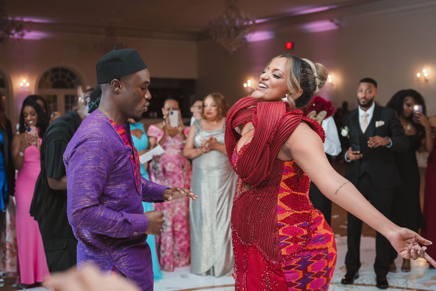 Wedding reception dance floor filled with guests in colorful formal attire.