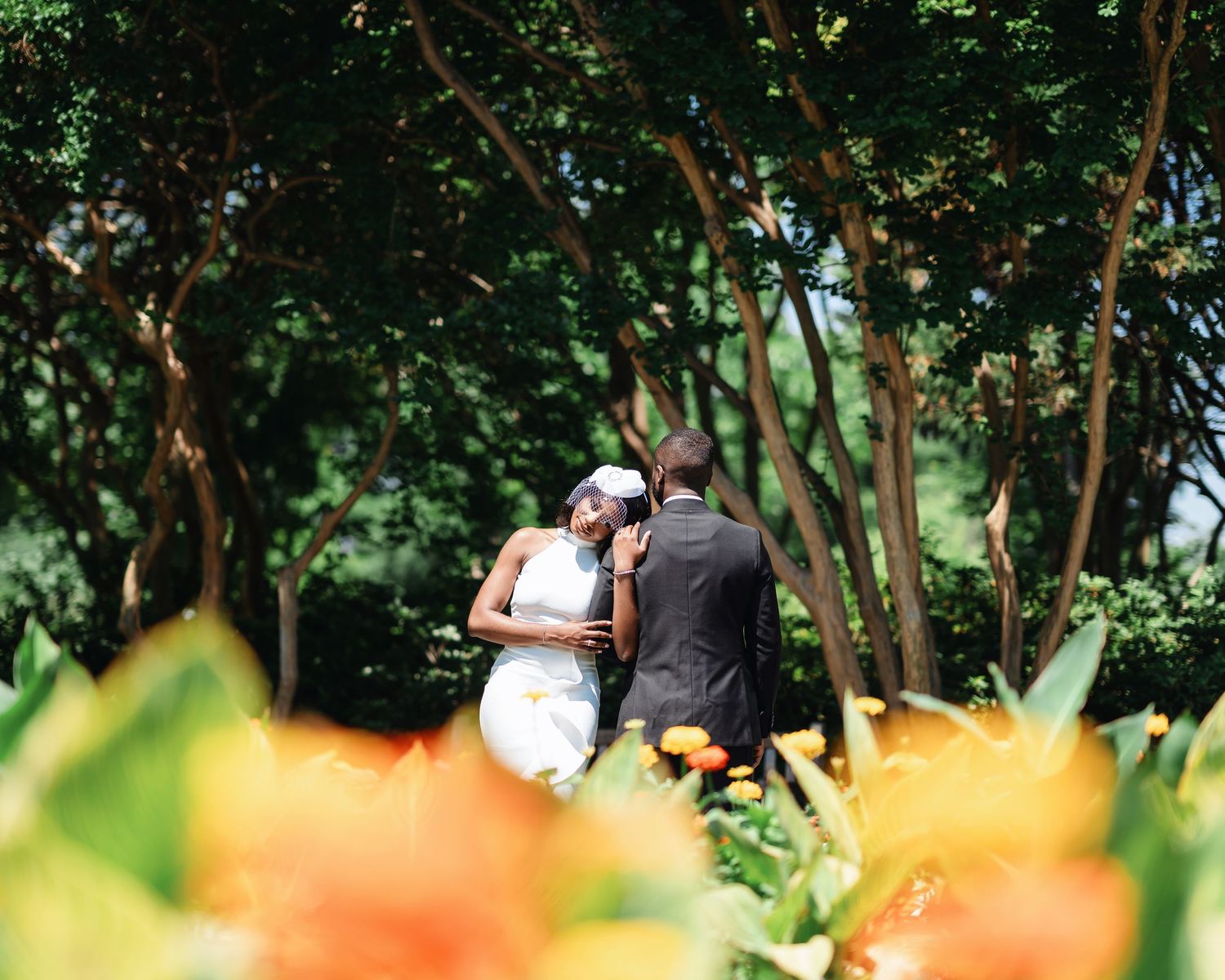 Colorful orange flowers bloom in a lush green garden setting on a sunny day.